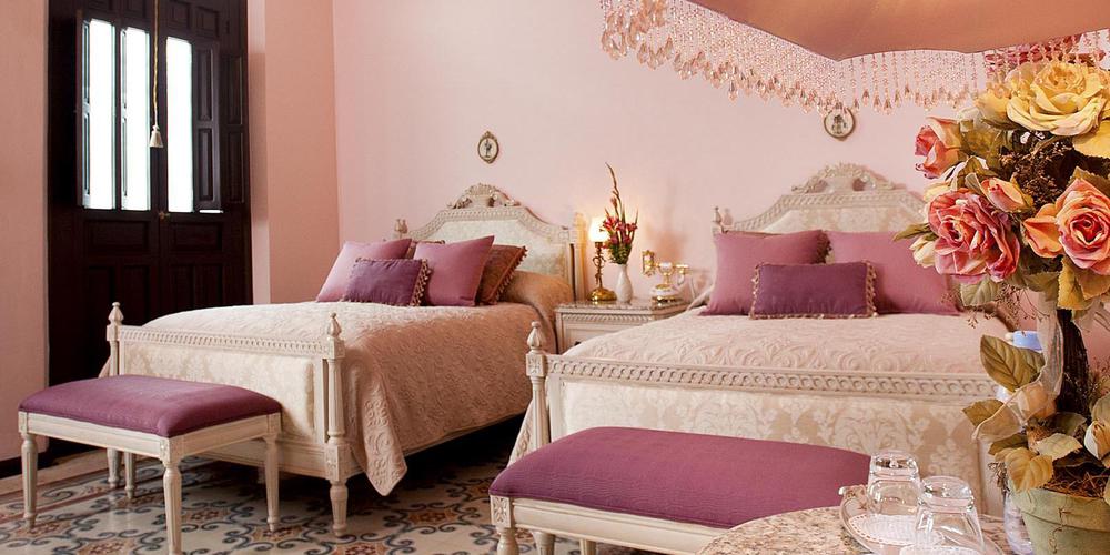 a bedroom with pink walls and pink bedding