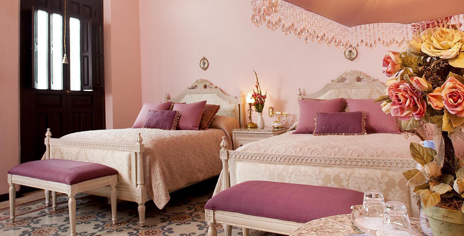 a bedroom with pink walls and pink bedding