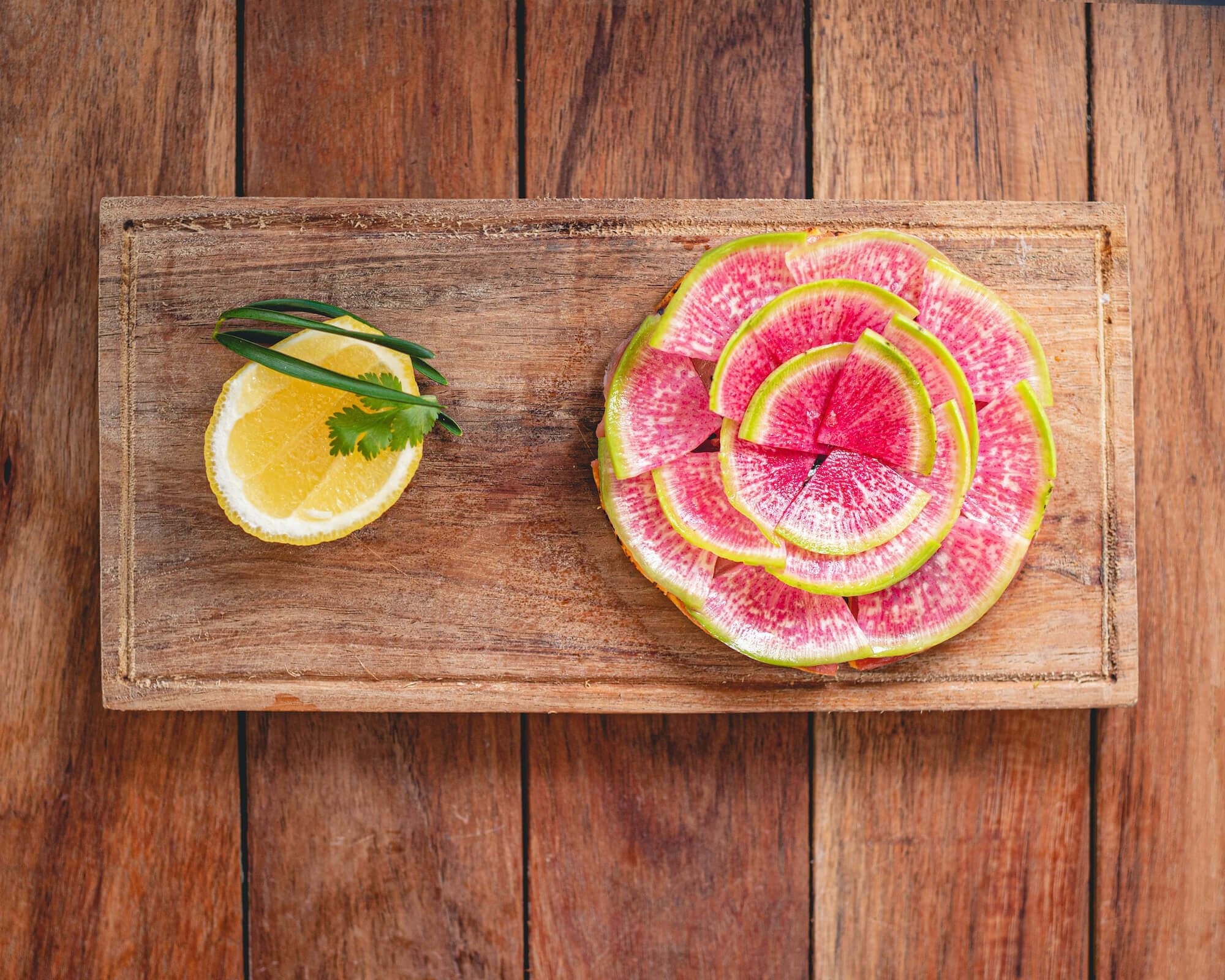 a sliced watermelon and lemon on a cutting board