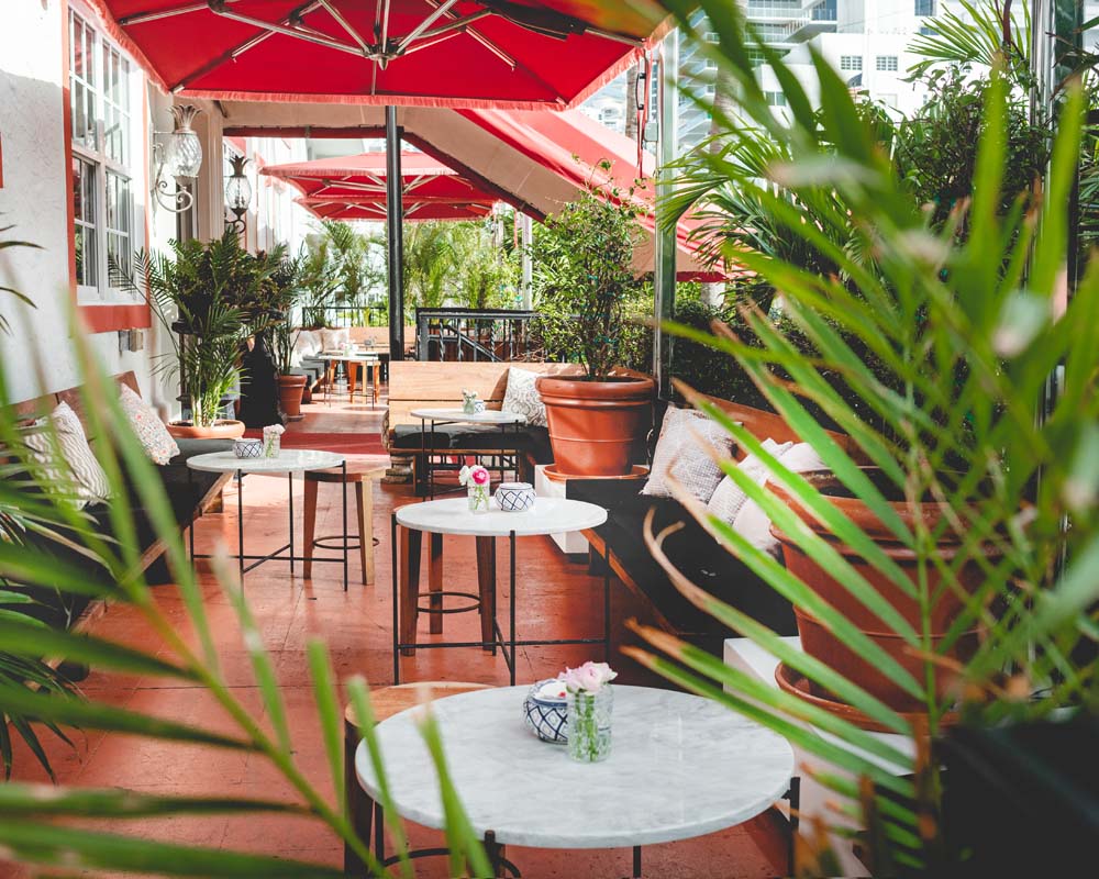 a patio with tables and chairs and umbrellas