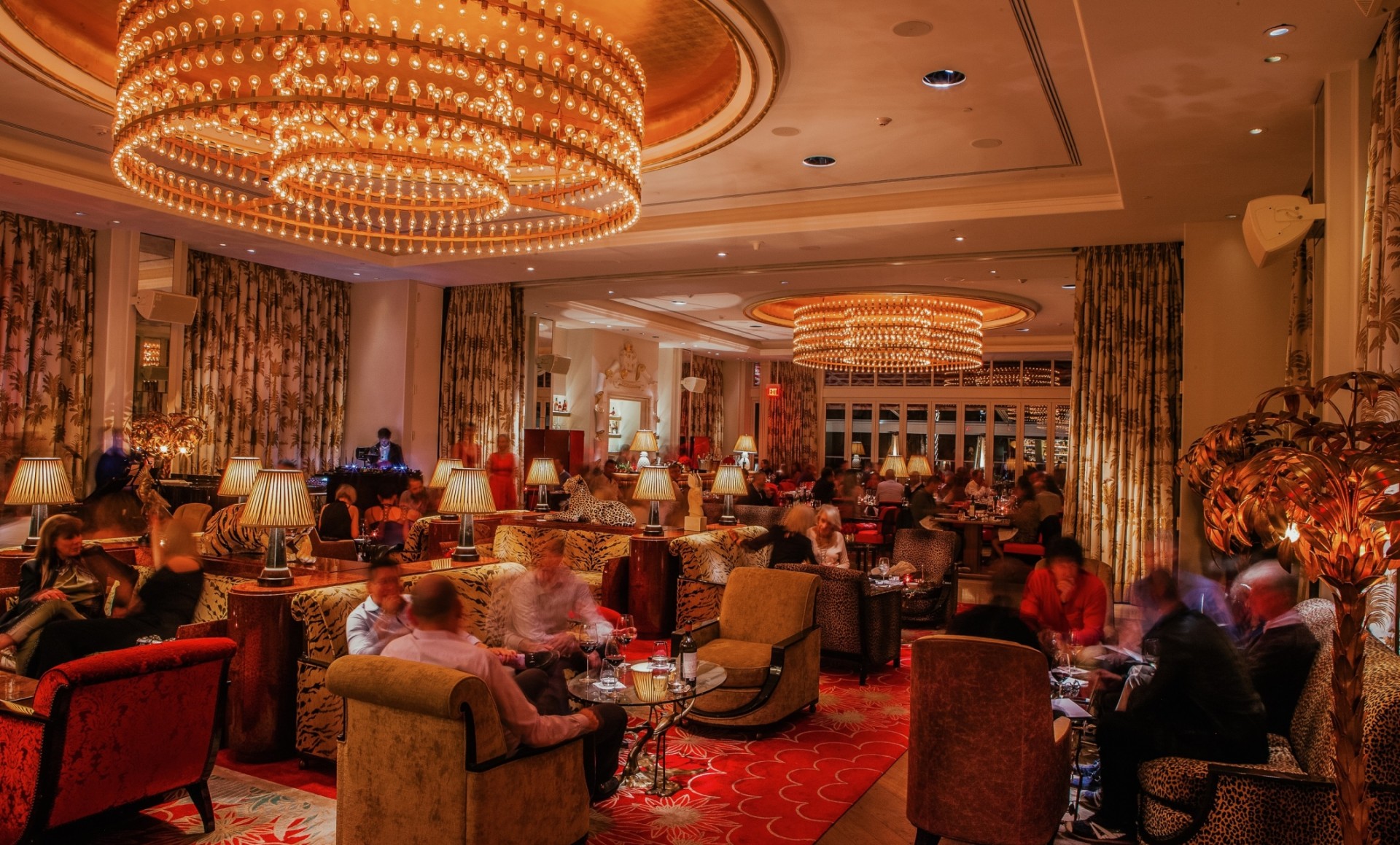 a group of people sitting in a room with chandeliers