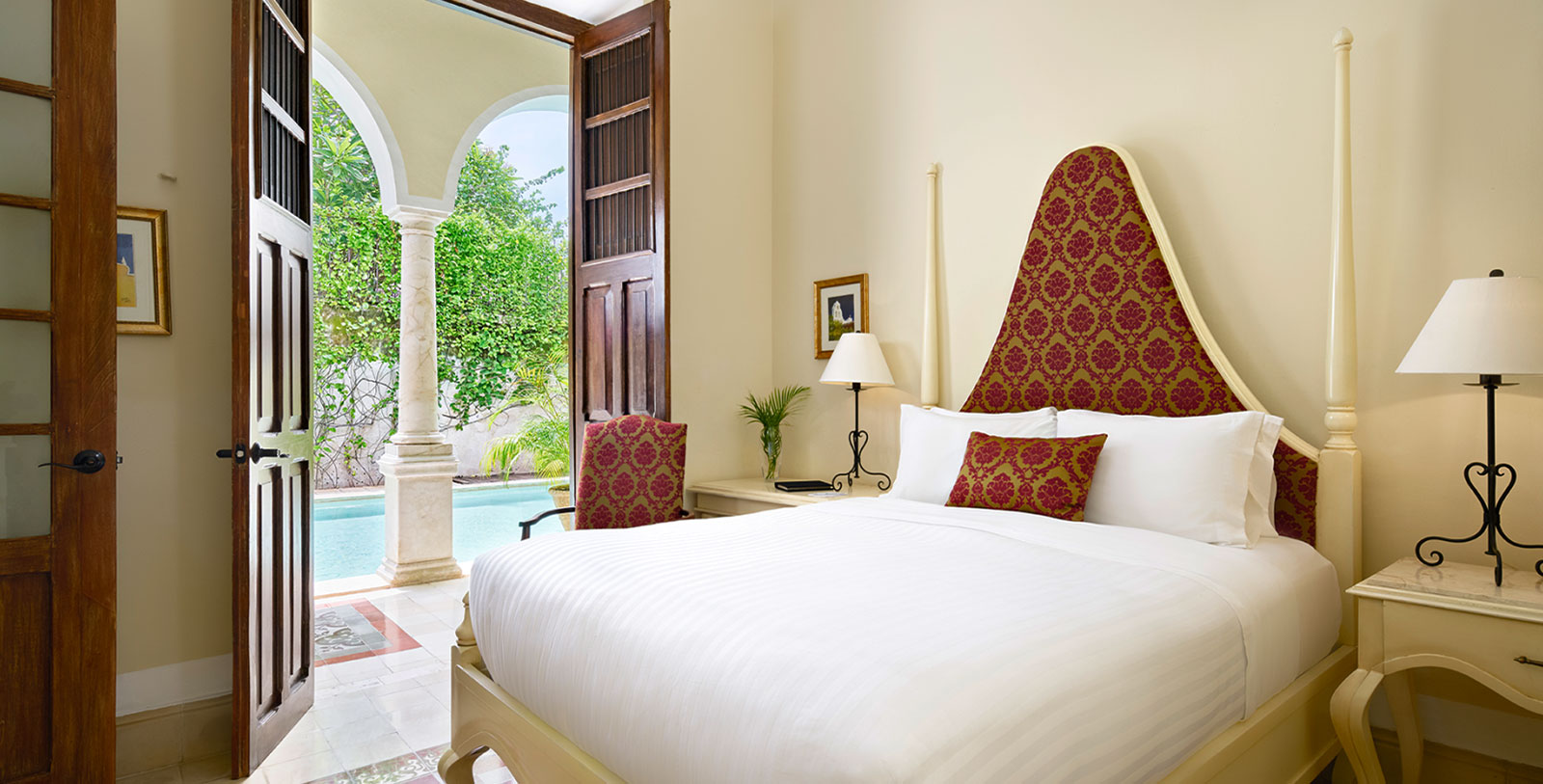 a bed with a red headboard and a lamp next to a pool