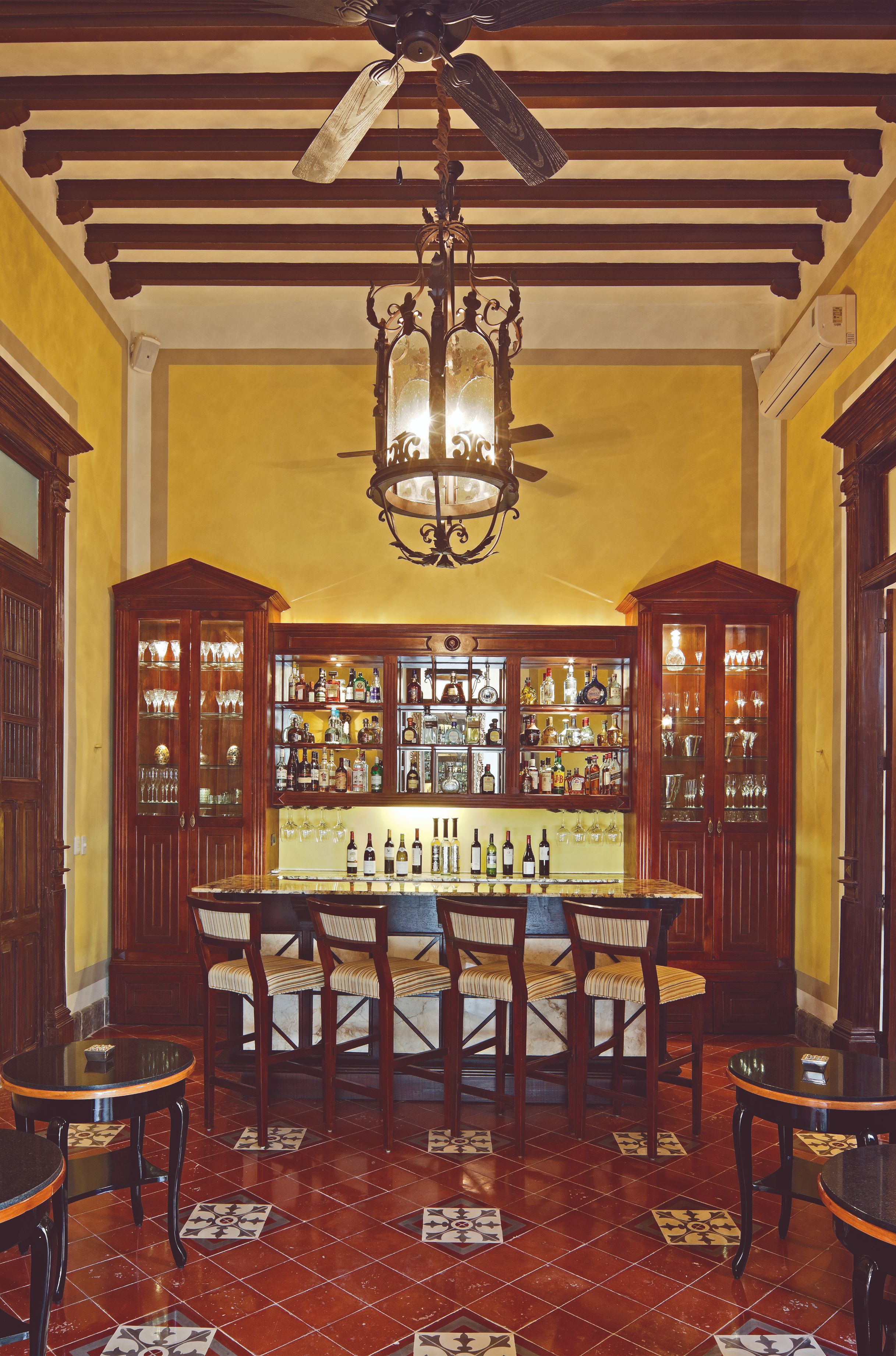 a room with a bar and shelves with bottles