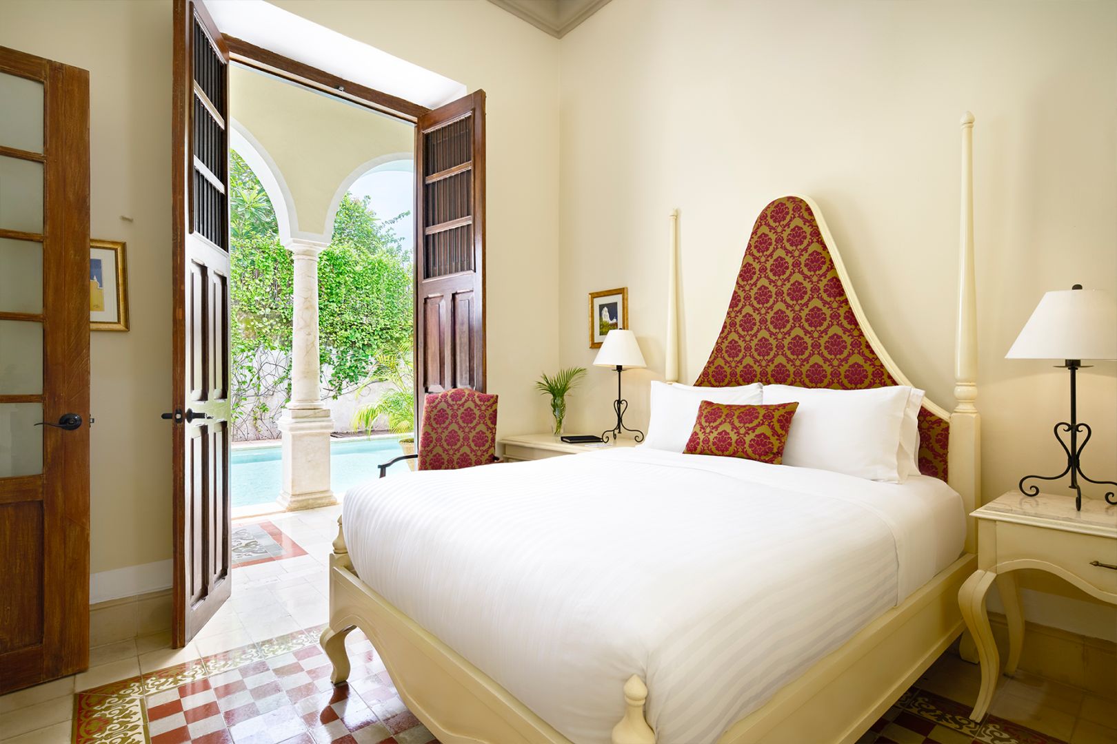 a bed with a red headboard and a lamp in a room with a pool