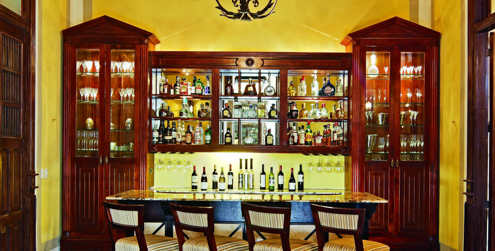 a bar with bottles of alcohol and chairs