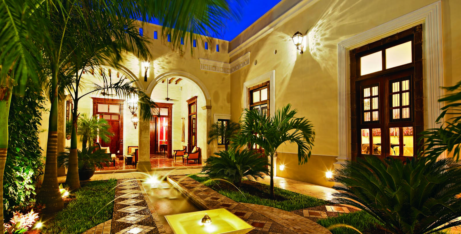 a courtyard with a fountain and palm trees