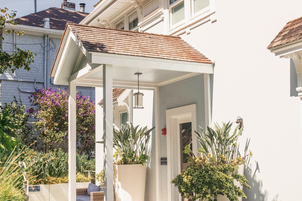 a white house with plants in pots