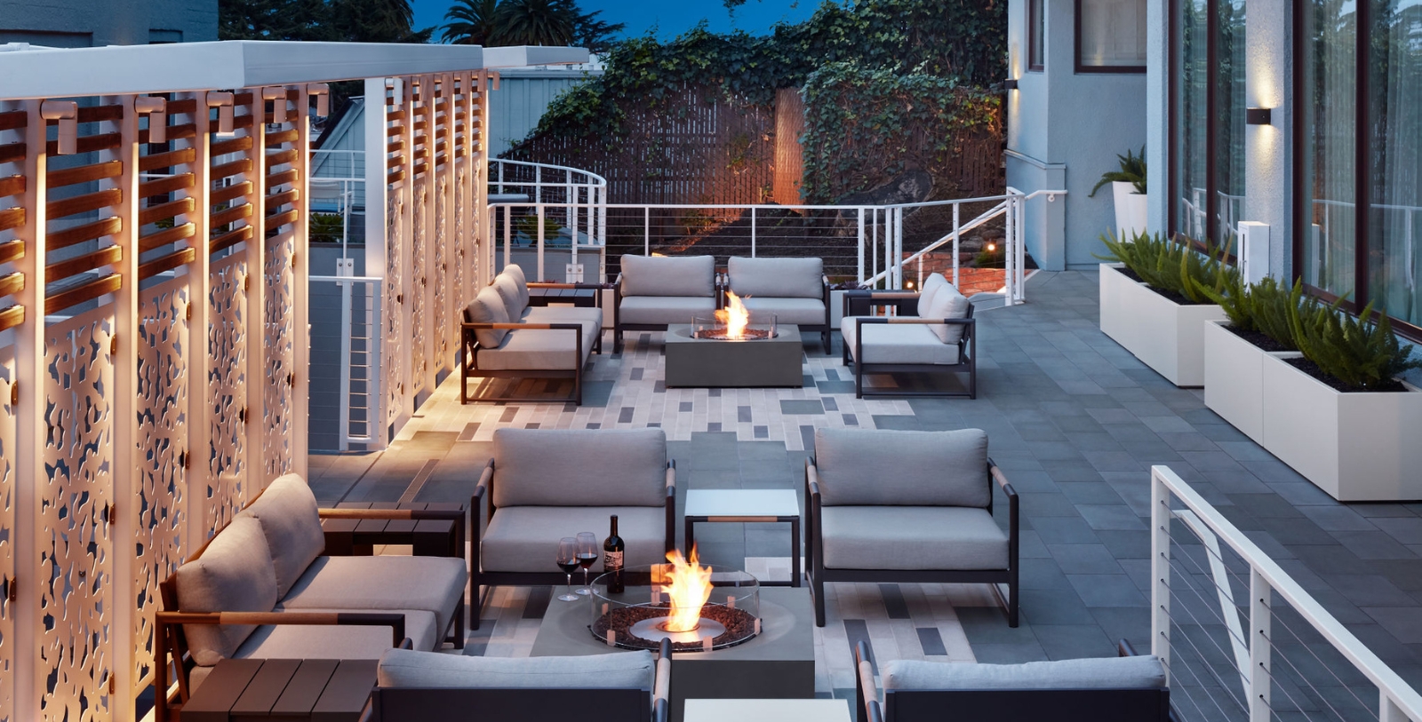 a patio with a fire pit and chairs