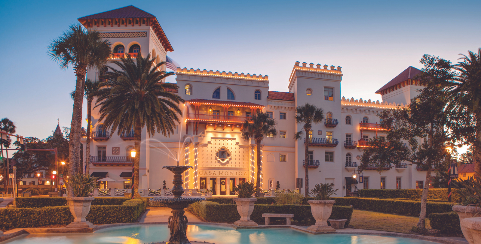 a building with a fountain and palm trees