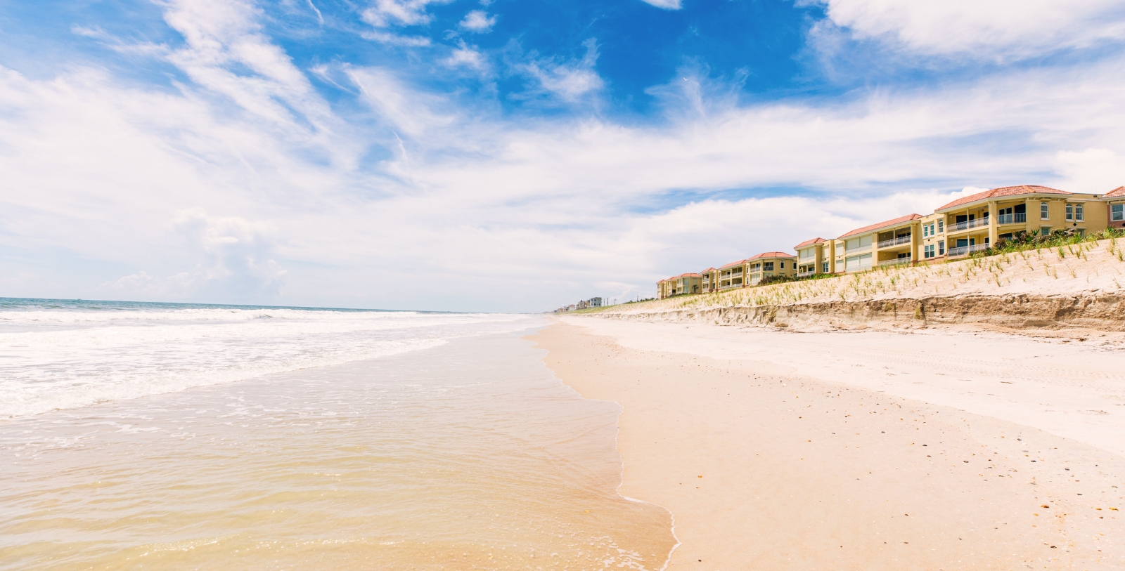 a beach with houses and waves