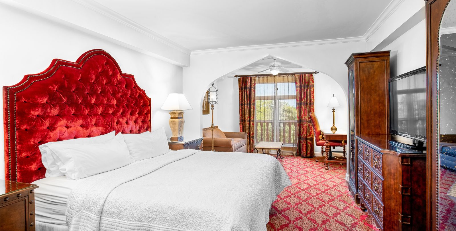a bedroom with a red headboard and a chair