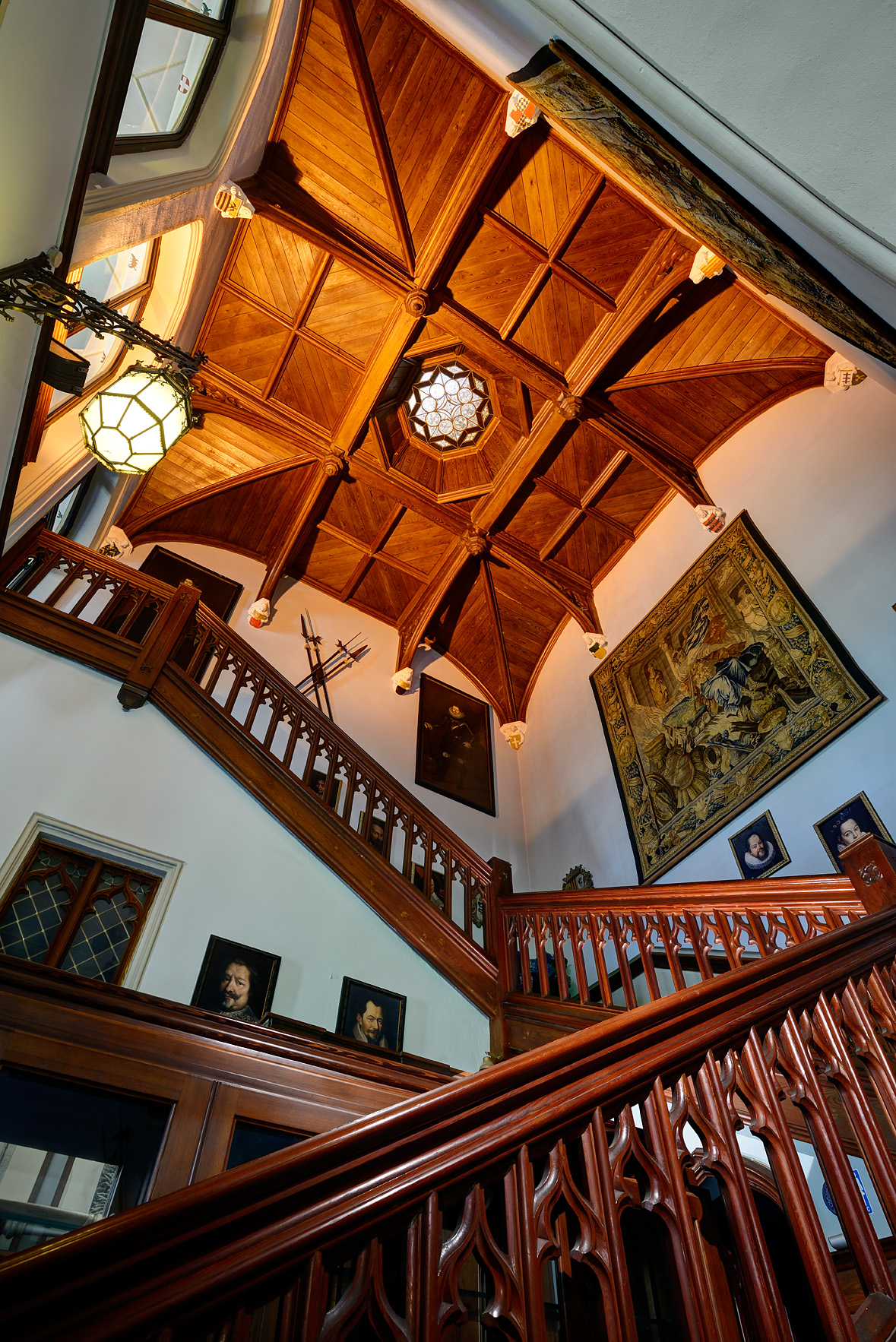 a staircase with a ceiling and a stained glass window