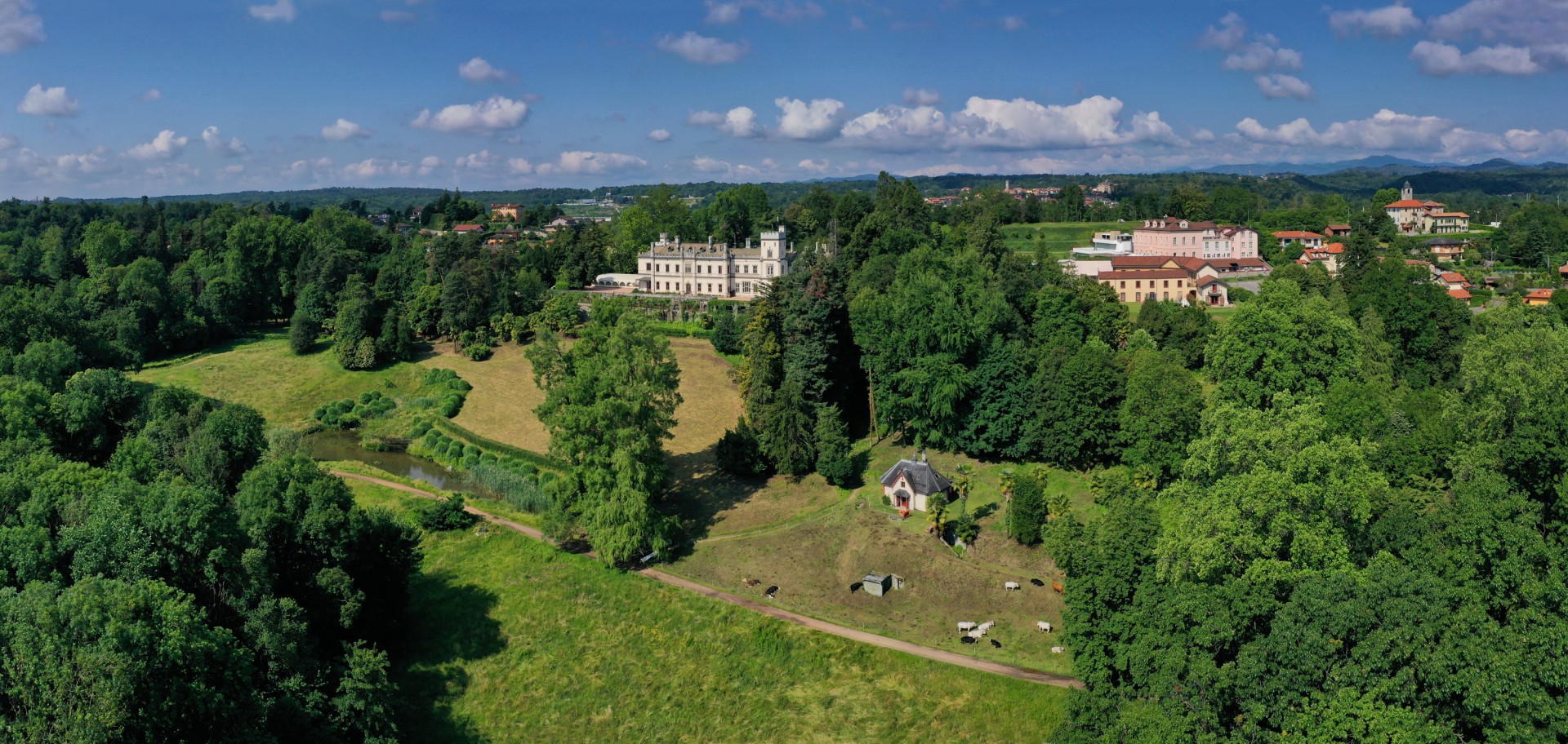 a large building with a large lawn and trees