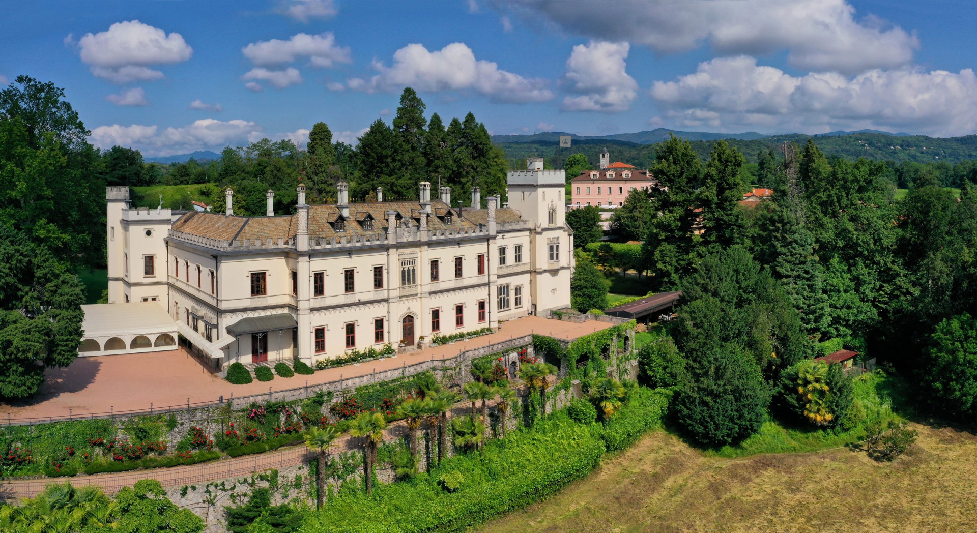 a large white building with trees and bushes
