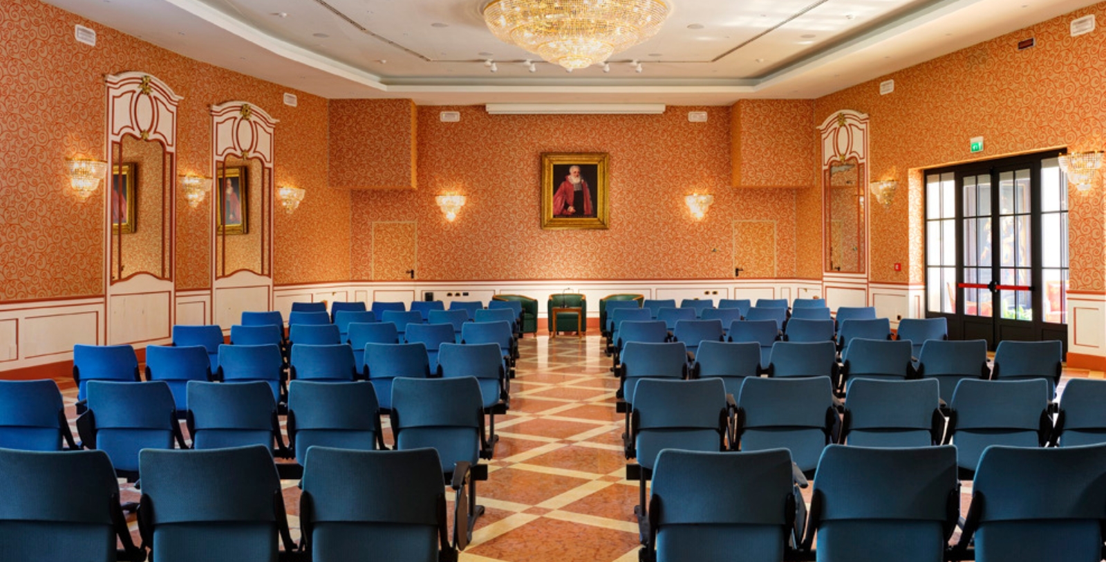 a room with blue chairs and a chandelier