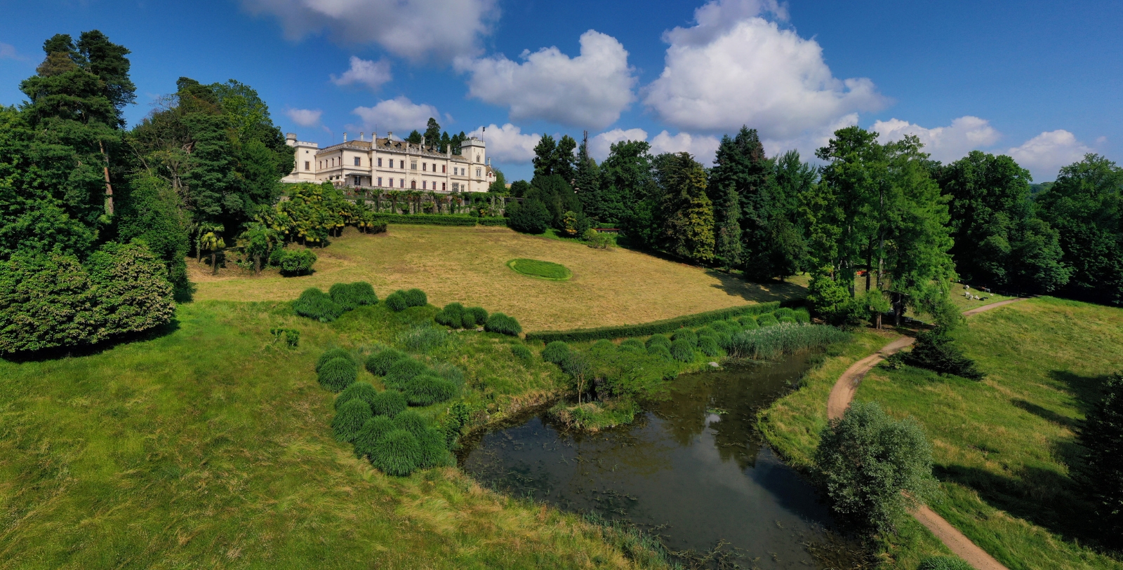a large white building with a river in front