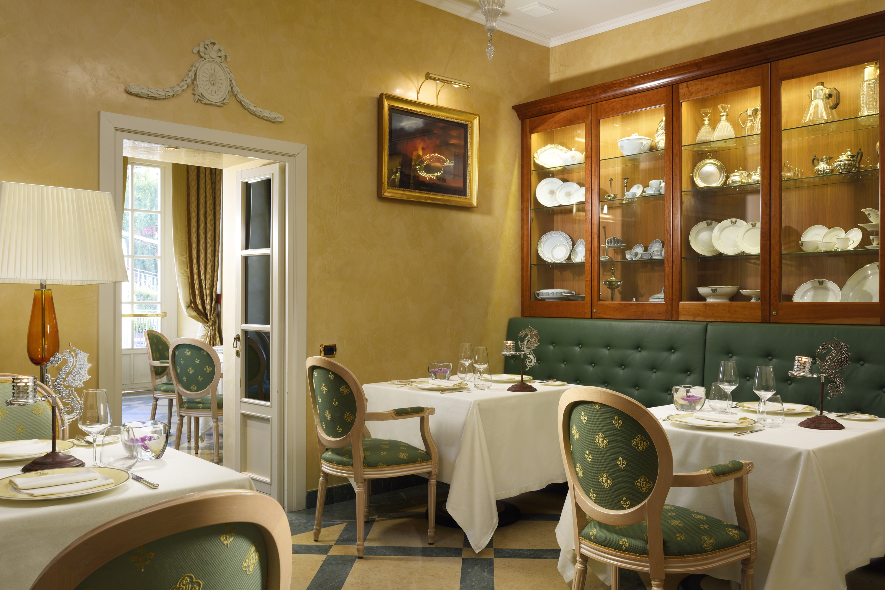 a restaurant with green booth and white tablecloths