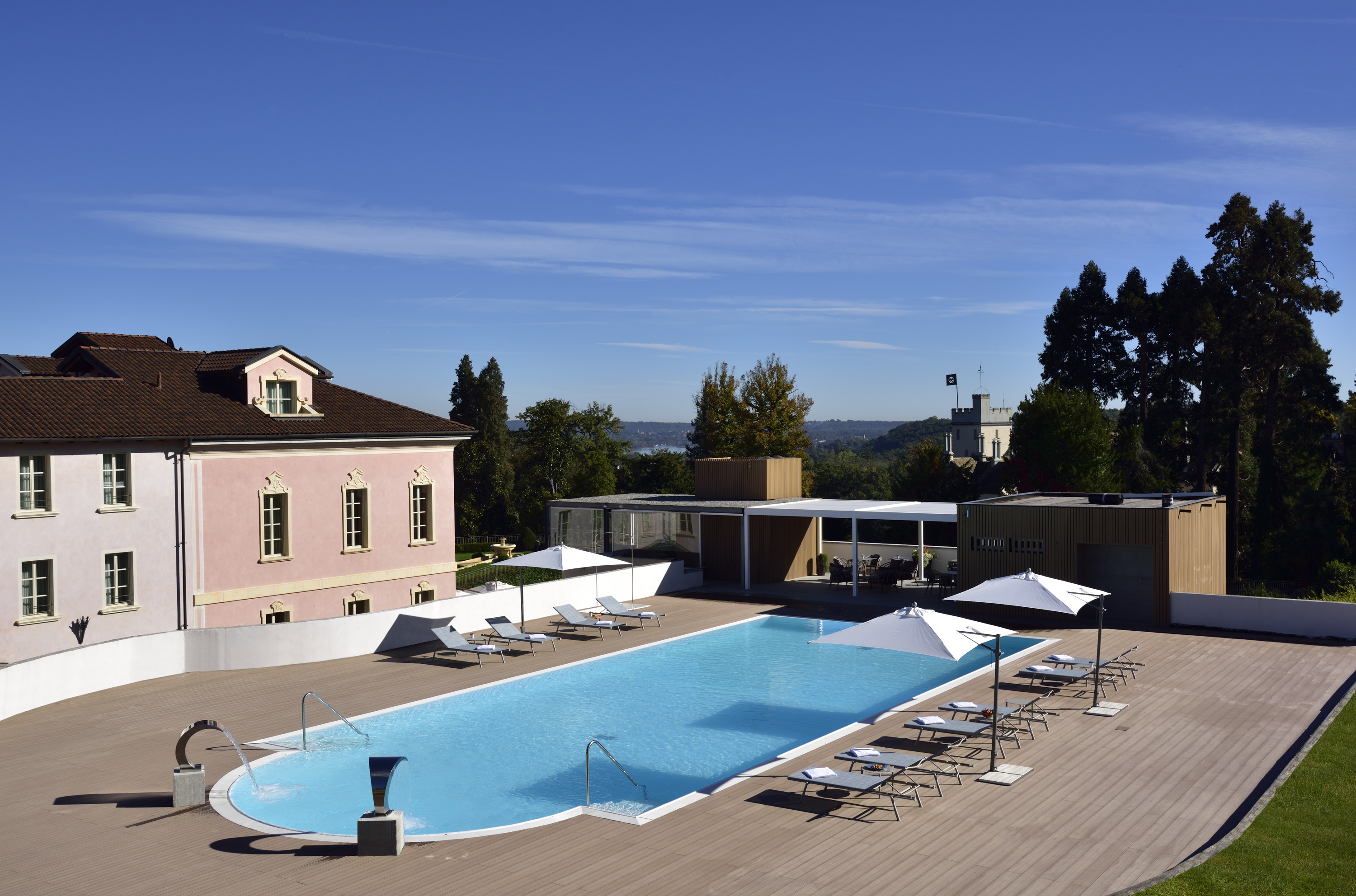 a pool with chairs and umbrellas on a deck