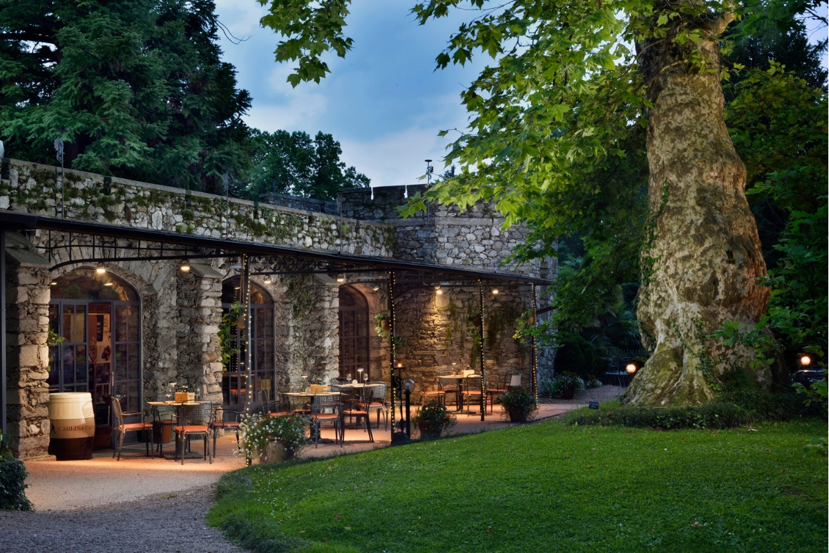 a stone building with tables and chairs outside