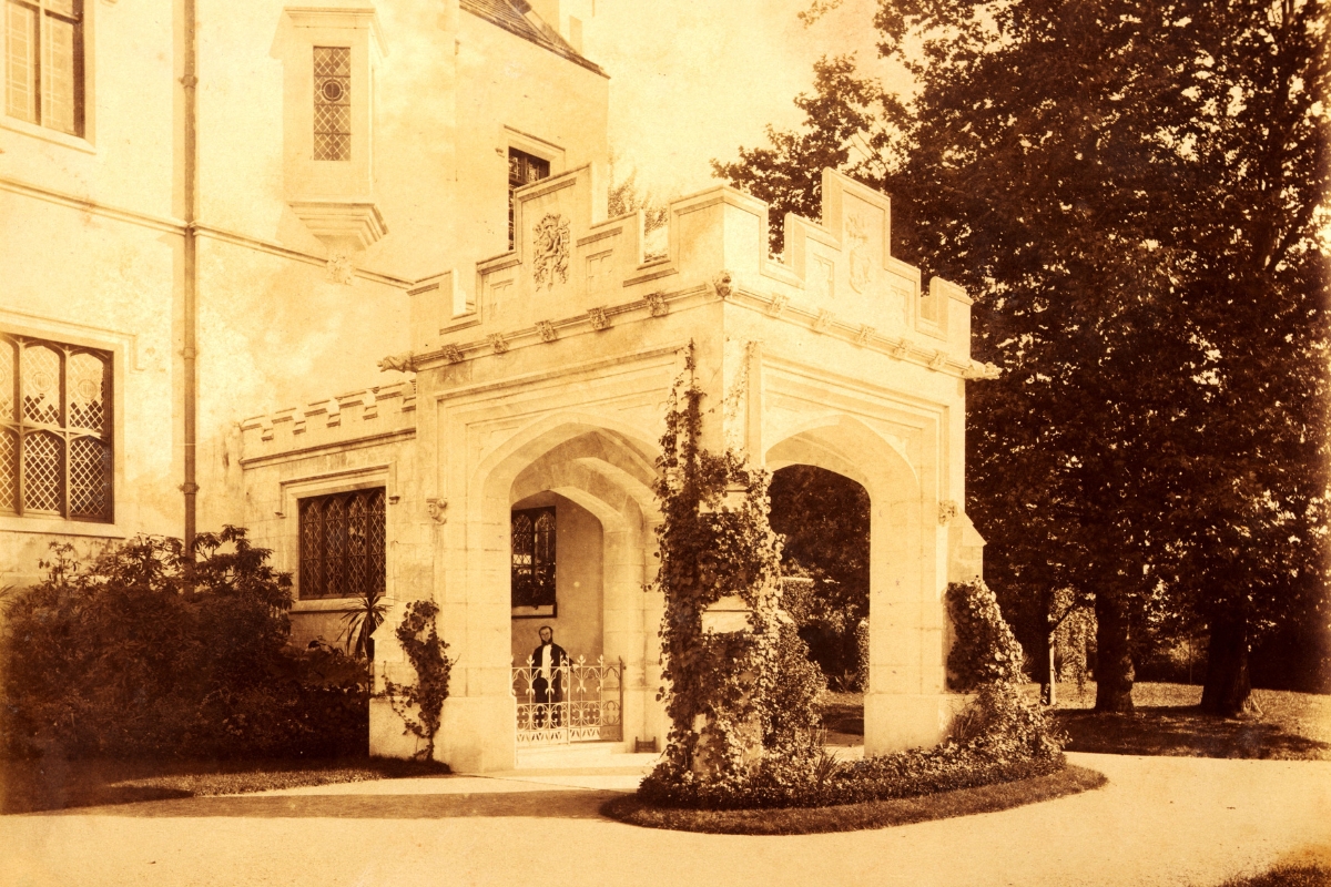 a white building with a gate and trees