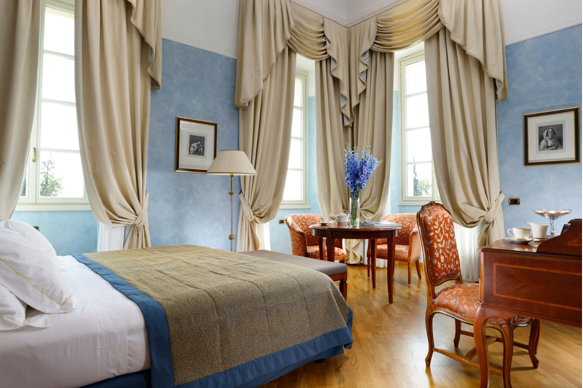 a room with a bed and chairs