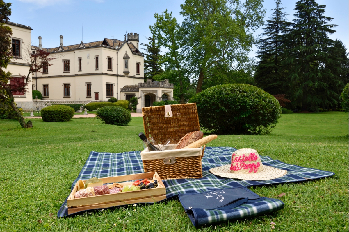 a picnic blanket and basket on a blanket in a park