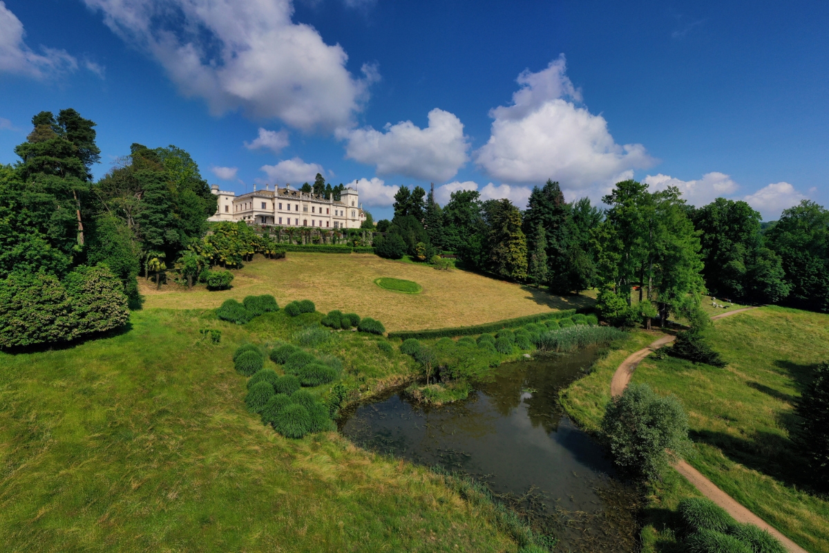 a large white building with a river in front