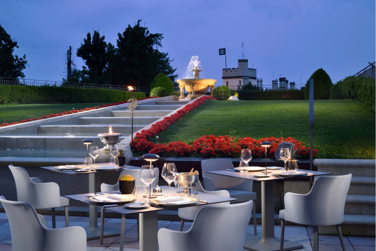 a table set up in a courtyard with a fountain and flowers