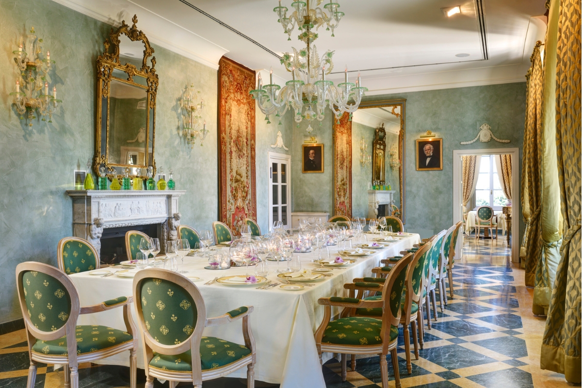 a large dining room with a chandelier and a table set for dinner