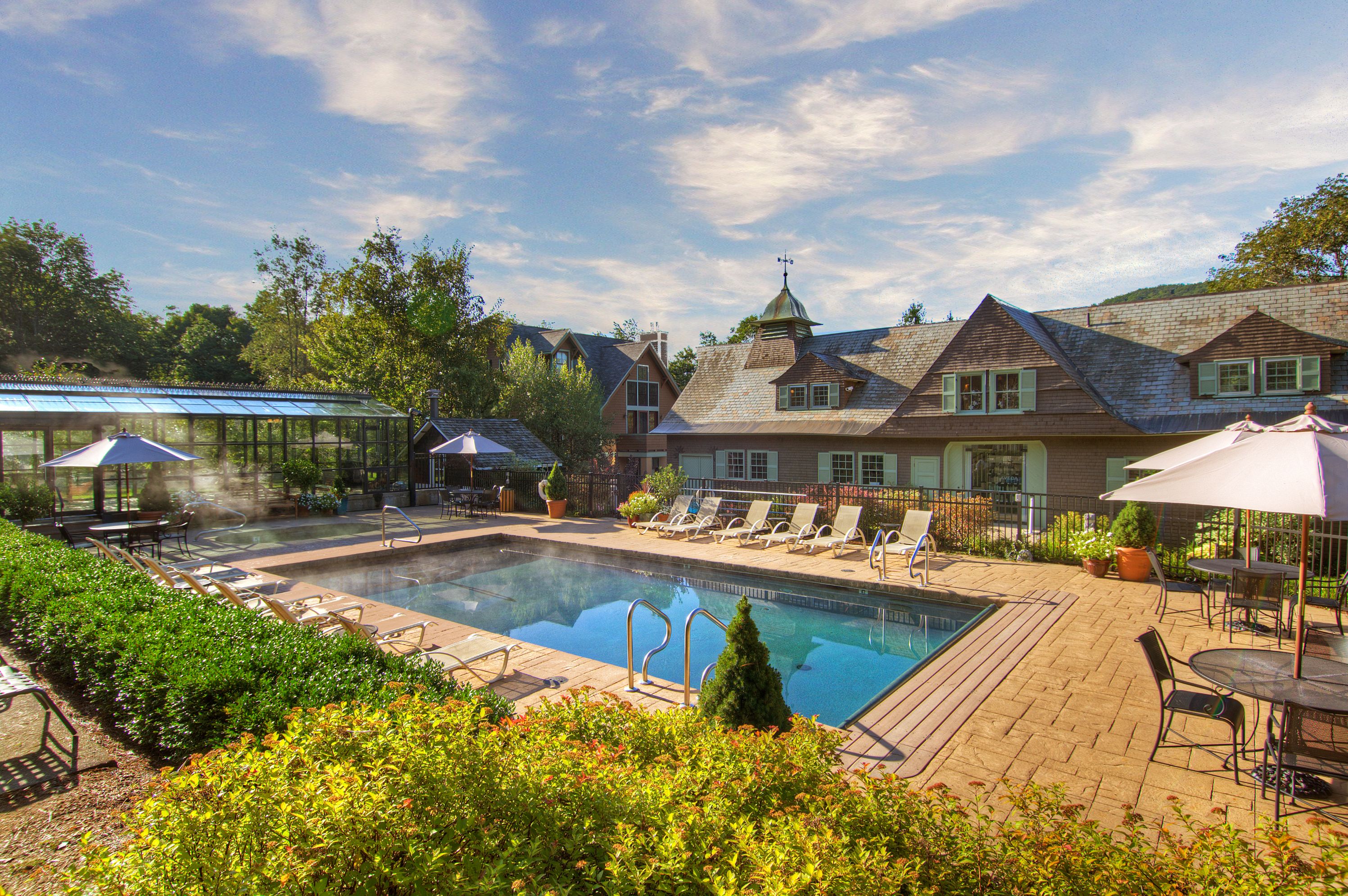 a pool with chairs and a house in the background