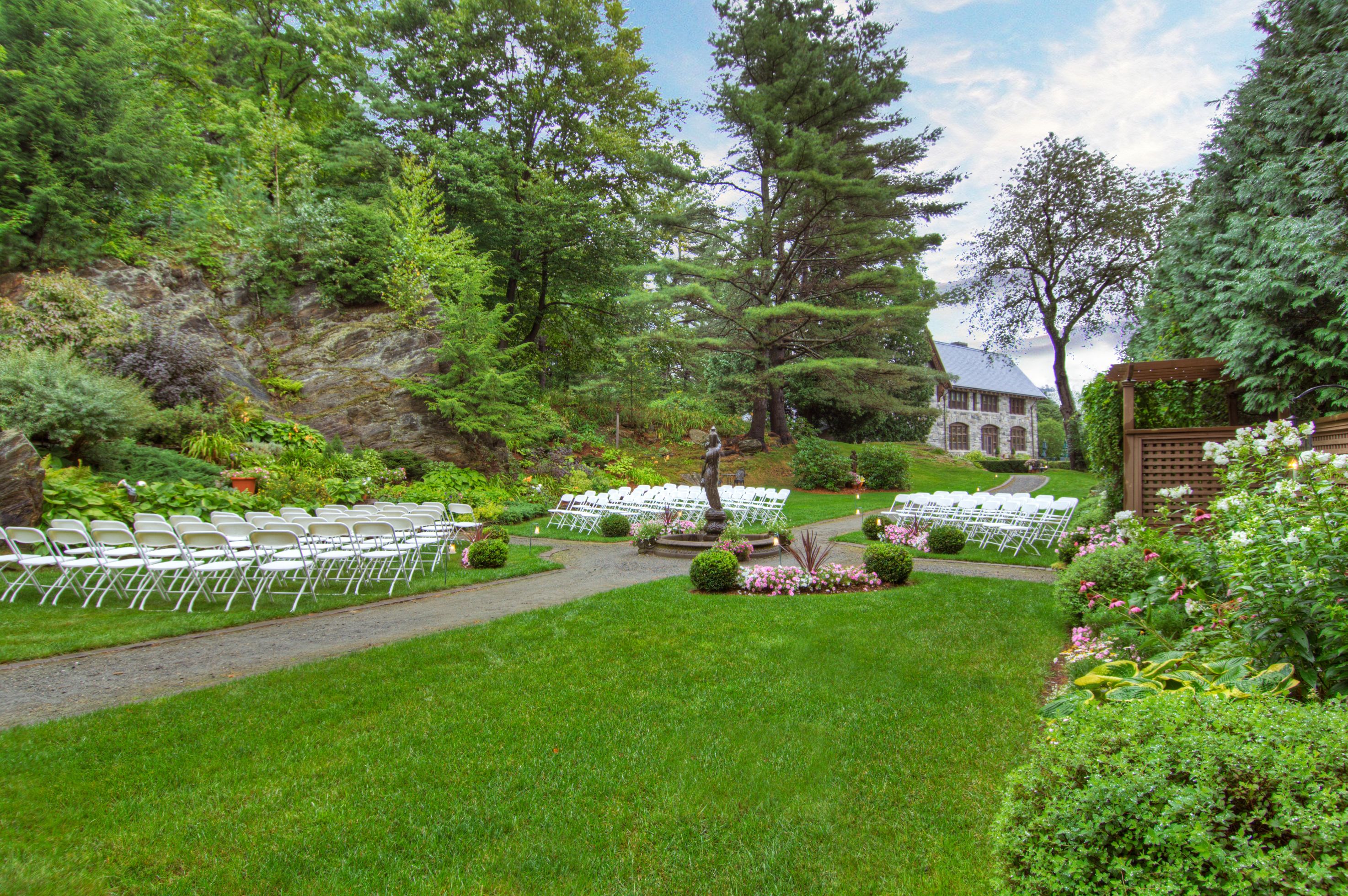 a lawn with chairs and a statue in the middle