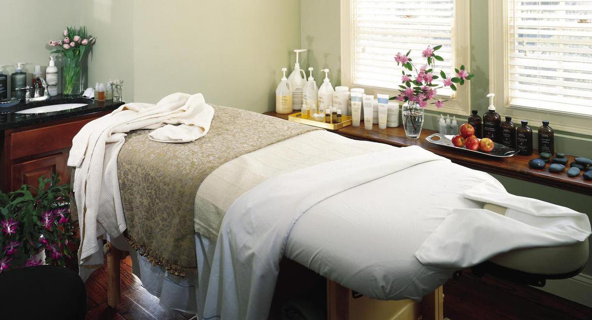 a massage table with a towel and bottles of cosmetics