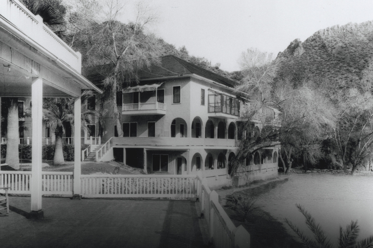 a building with a white fence and trees
