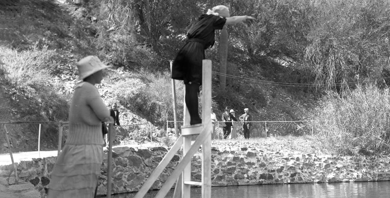 a woman jumping into a pool