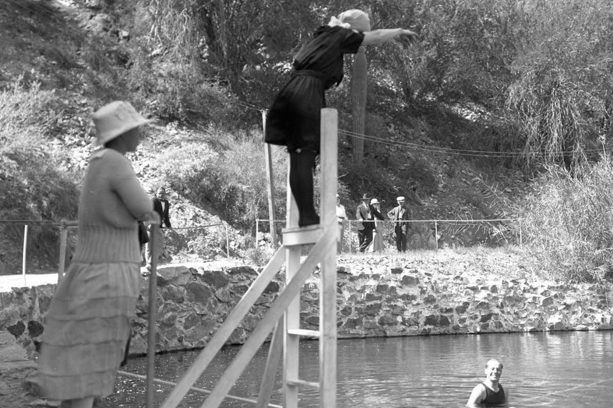 a woman jumping into a pool