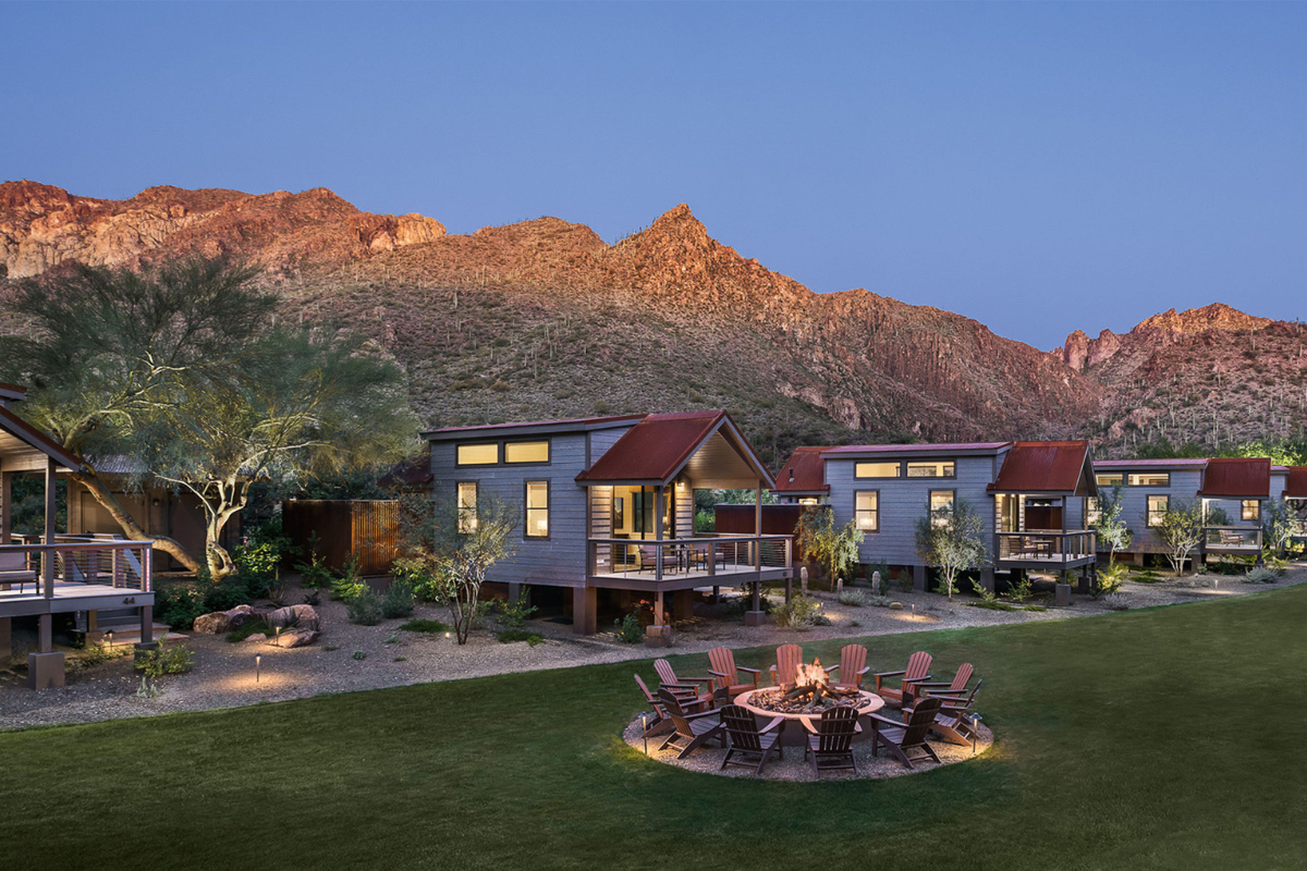 a group of houses with a fire pit in front of a mountain
