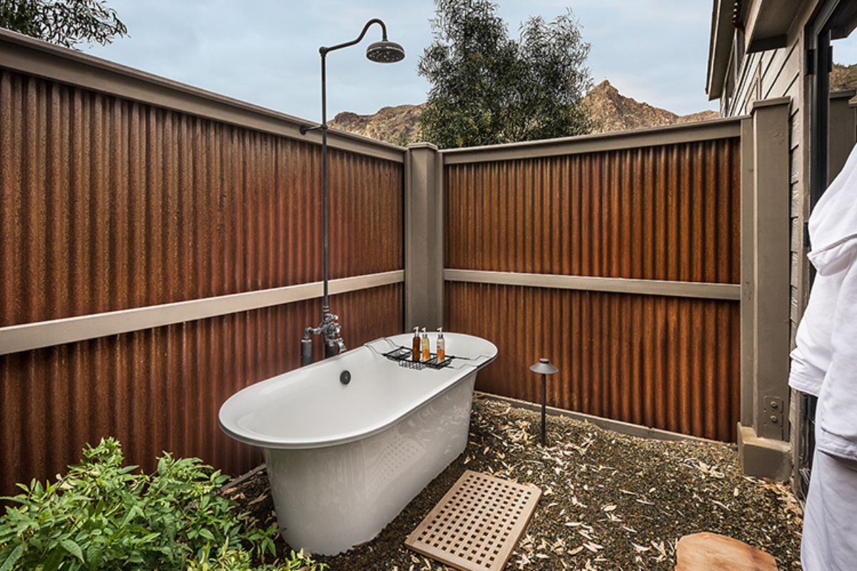 a bathtub outside with a shower and a shower head