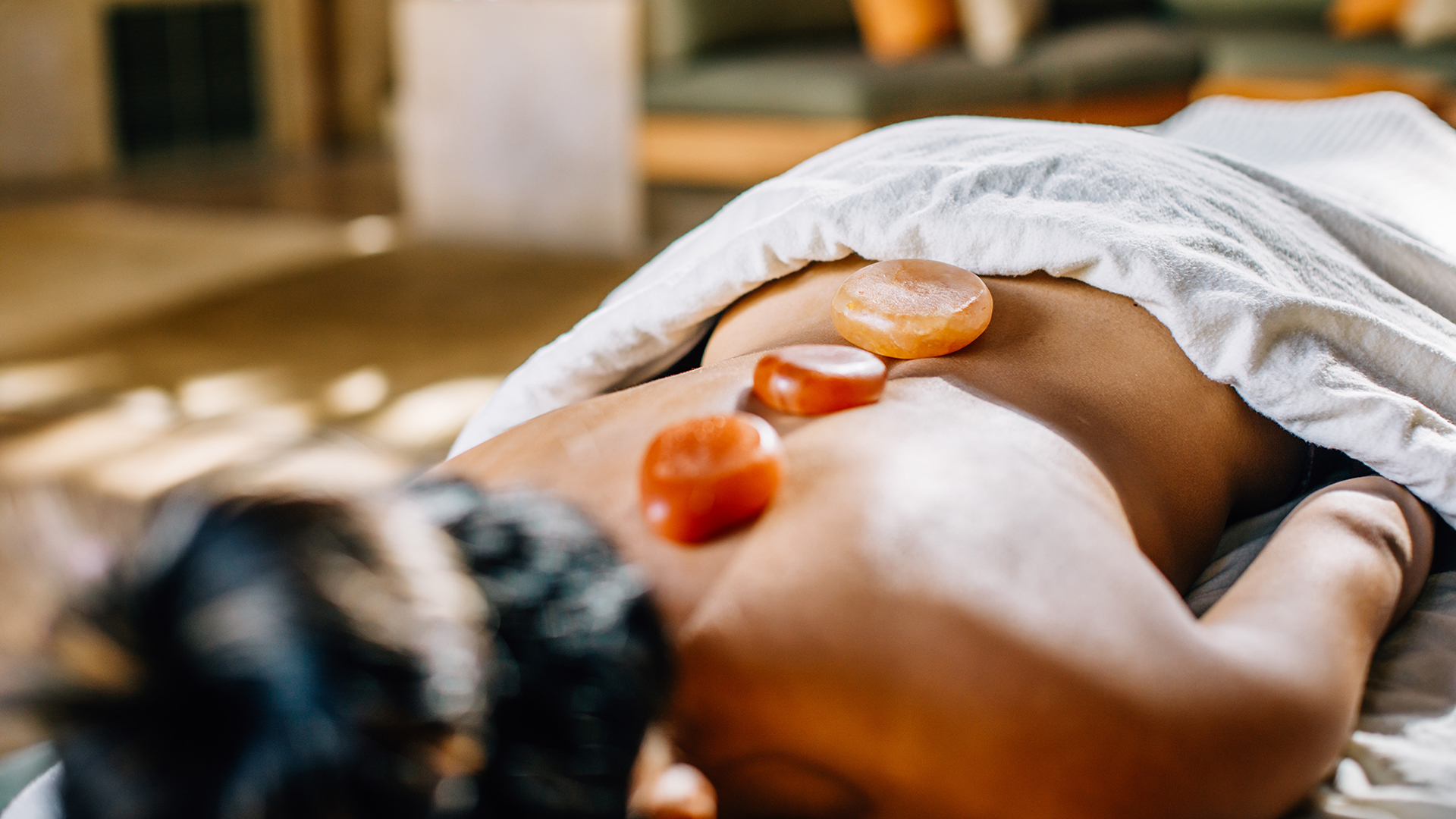 a person lying down with stones on their back