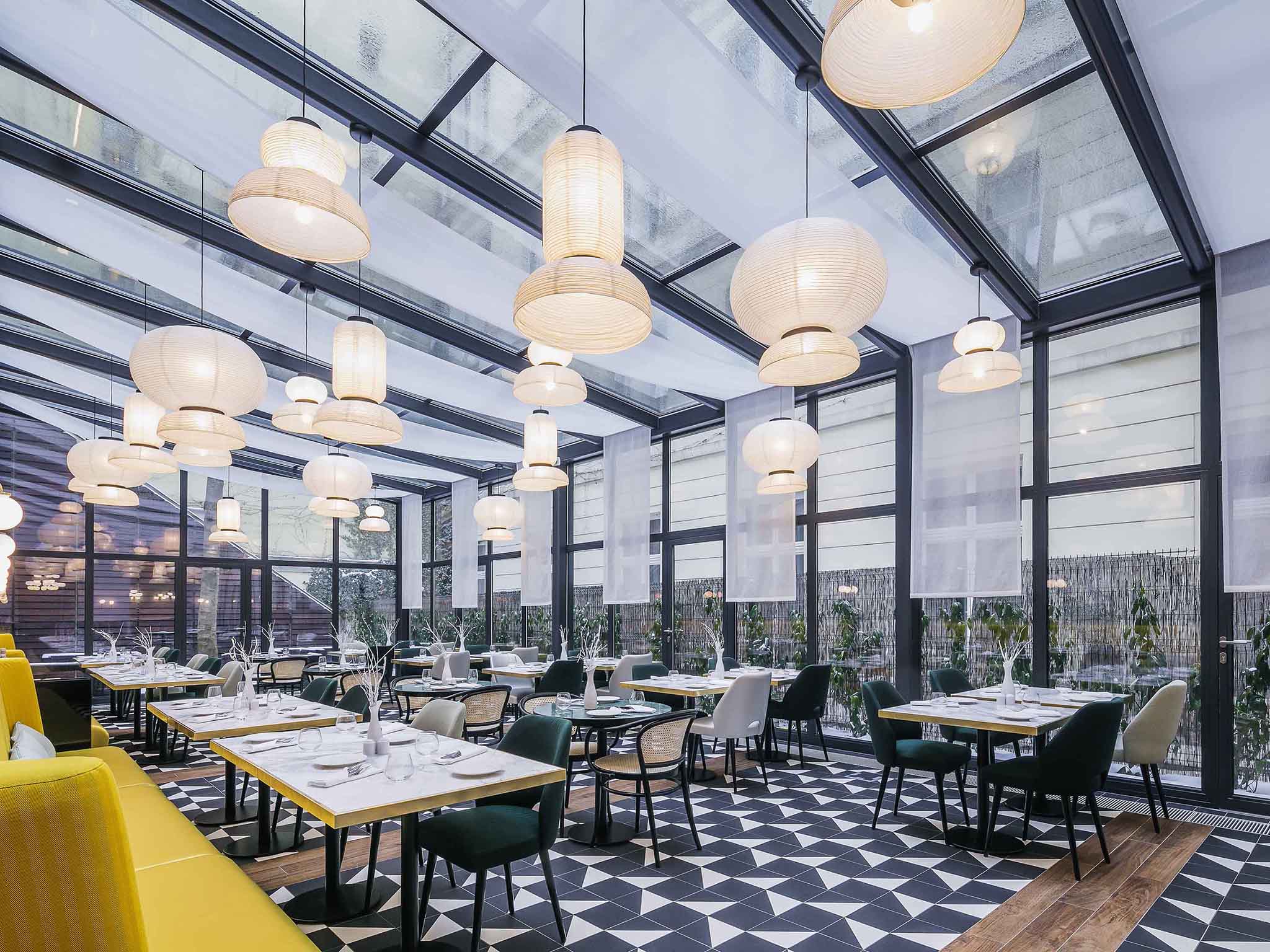 a room with tables and chairs and a black and white checkered floor