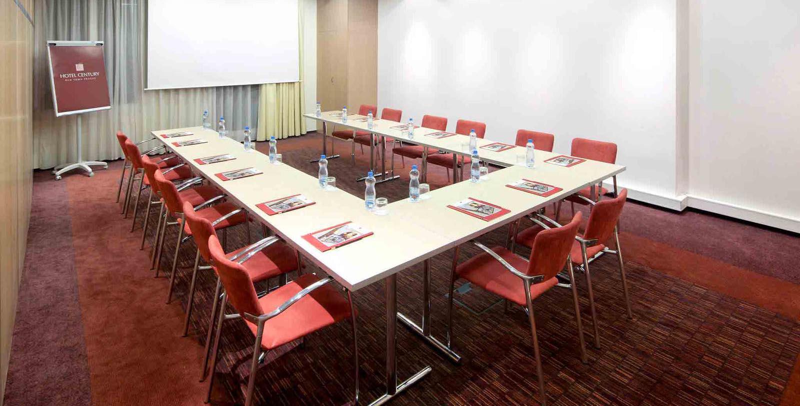 a long table with chairs and water bottles