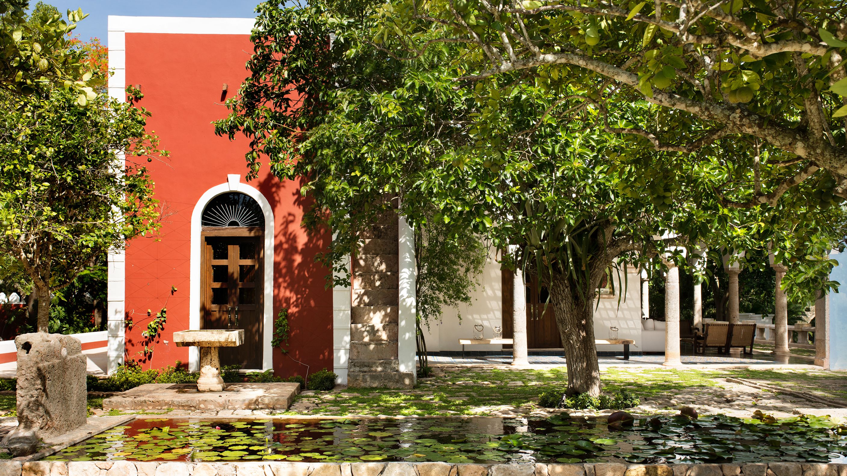 a building with trees and a stone fountain