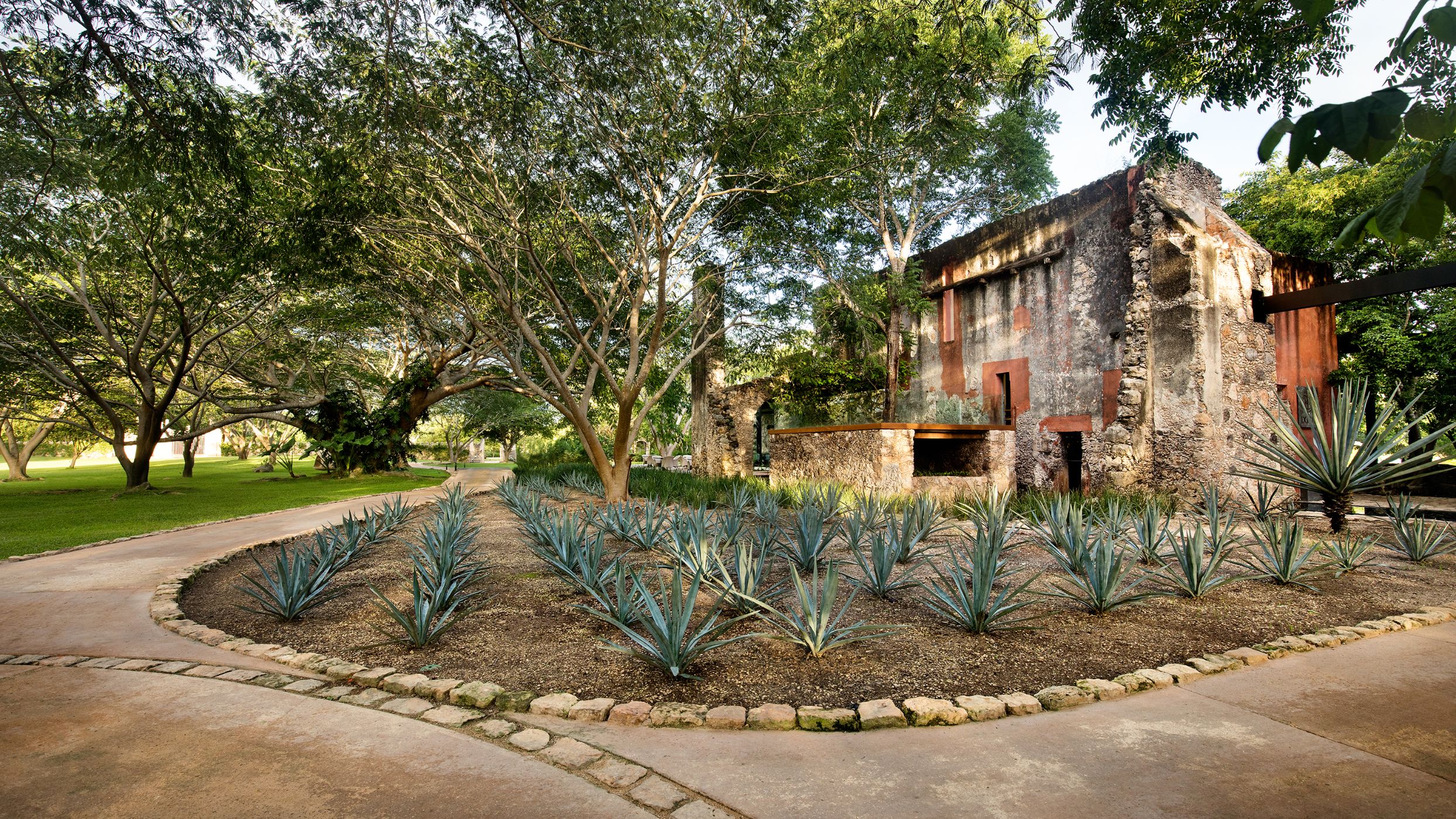 a garden with trees and a stone building