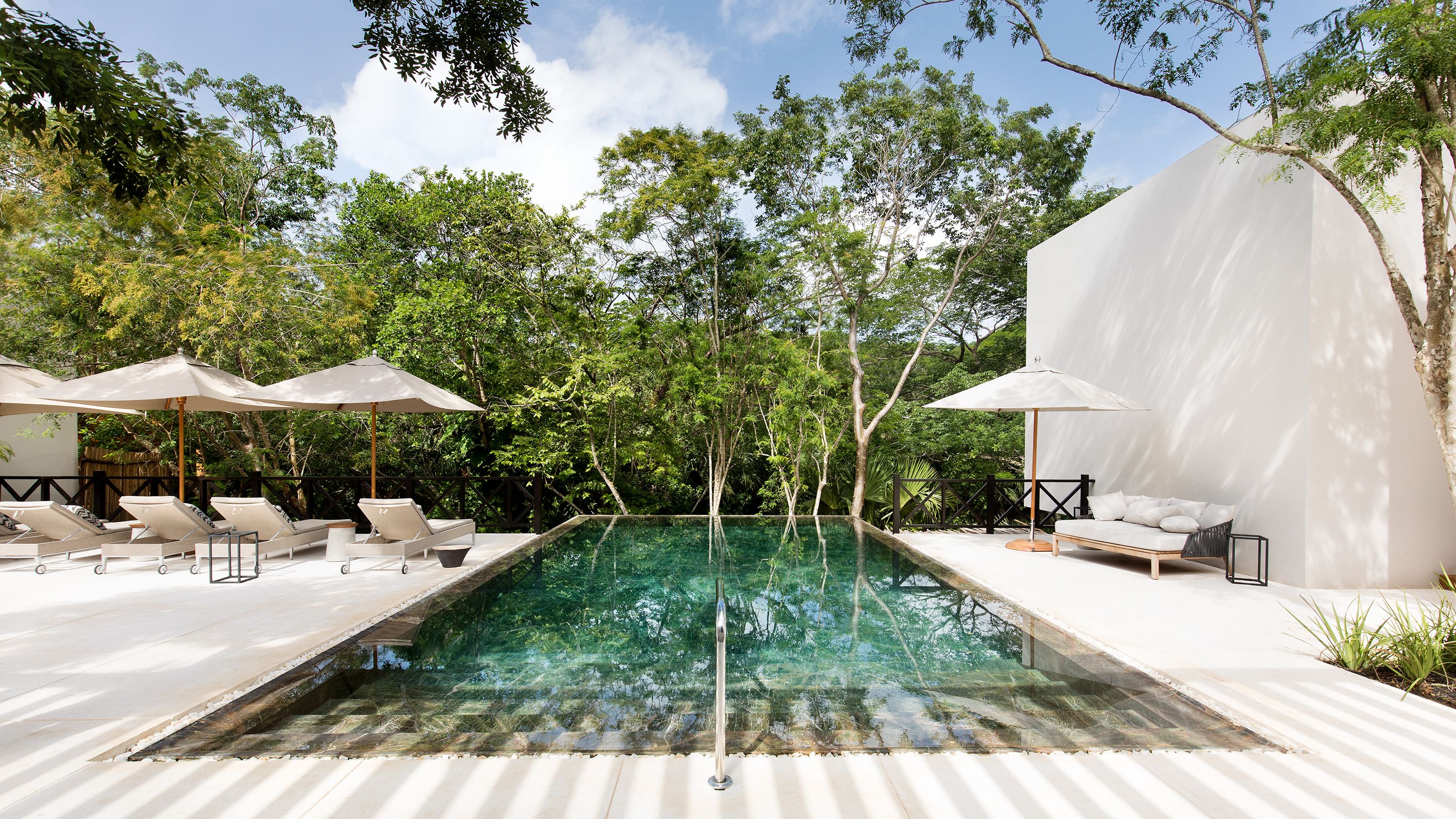 a pool with umbrellas and chairs in the back