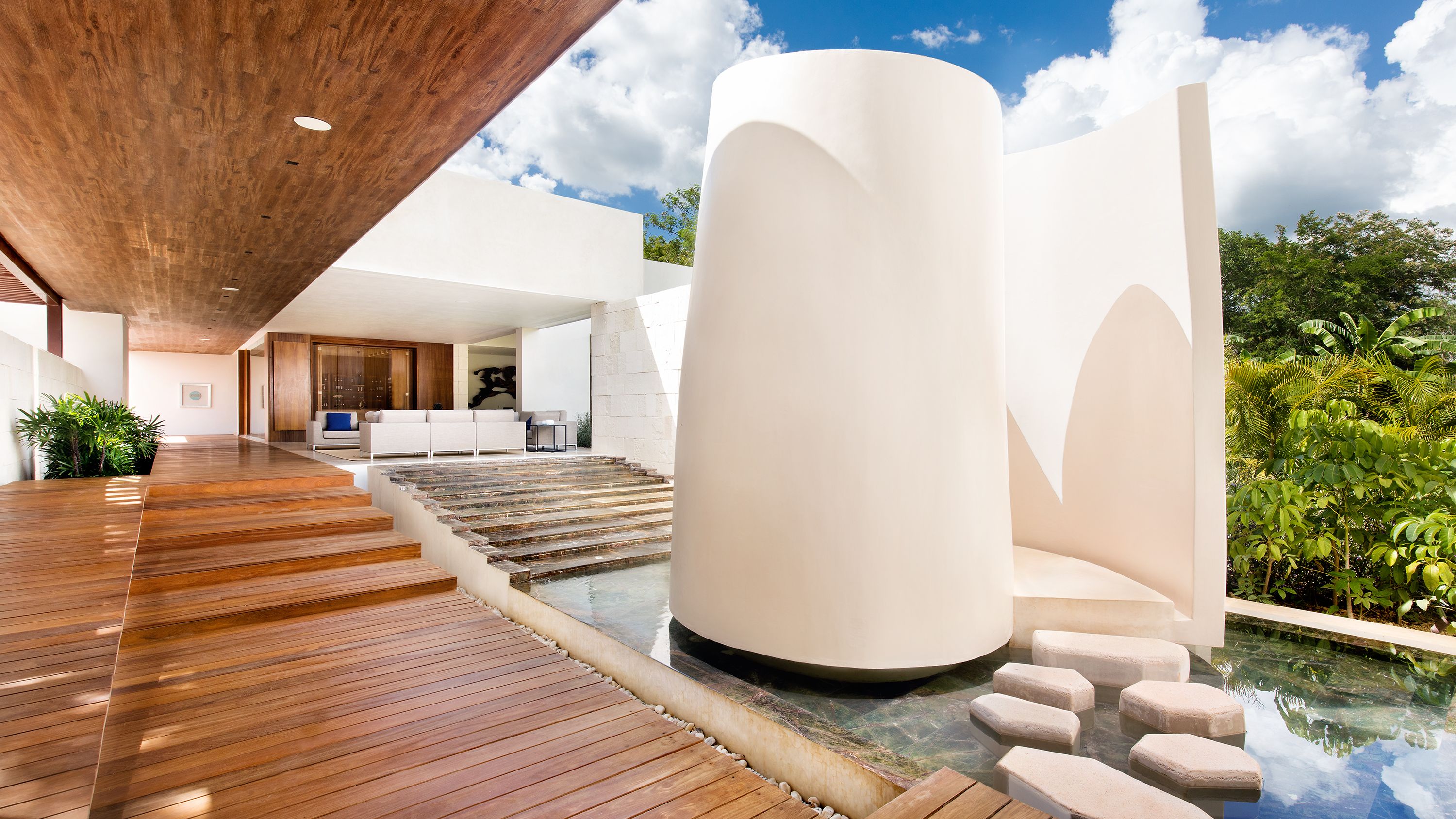 a white building with a pool and a wooden deck