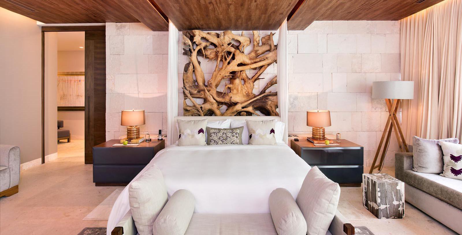 a bed with a white cover and pillows in a room with a wood wall