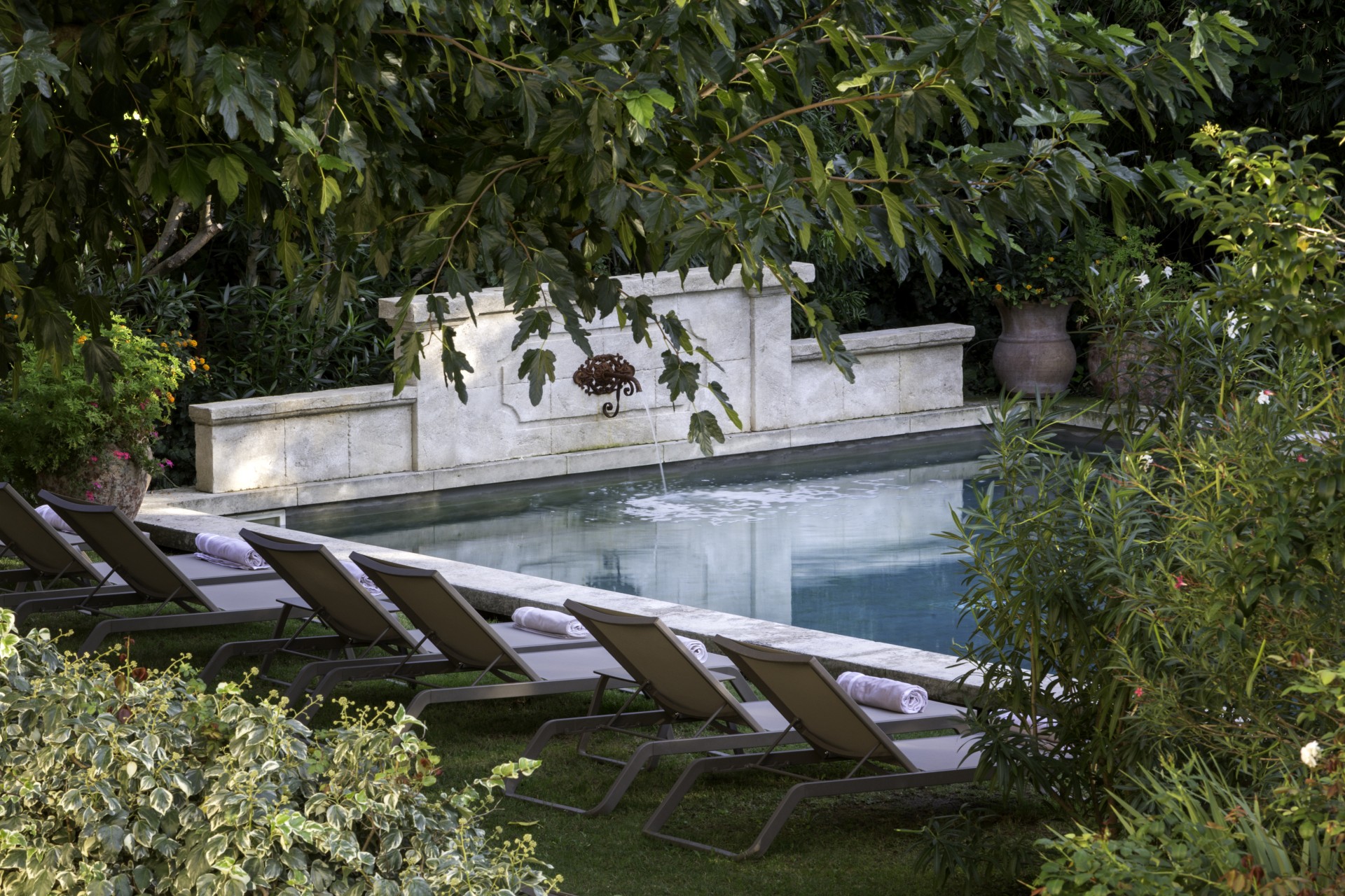 a pool with lounge chairs and trees