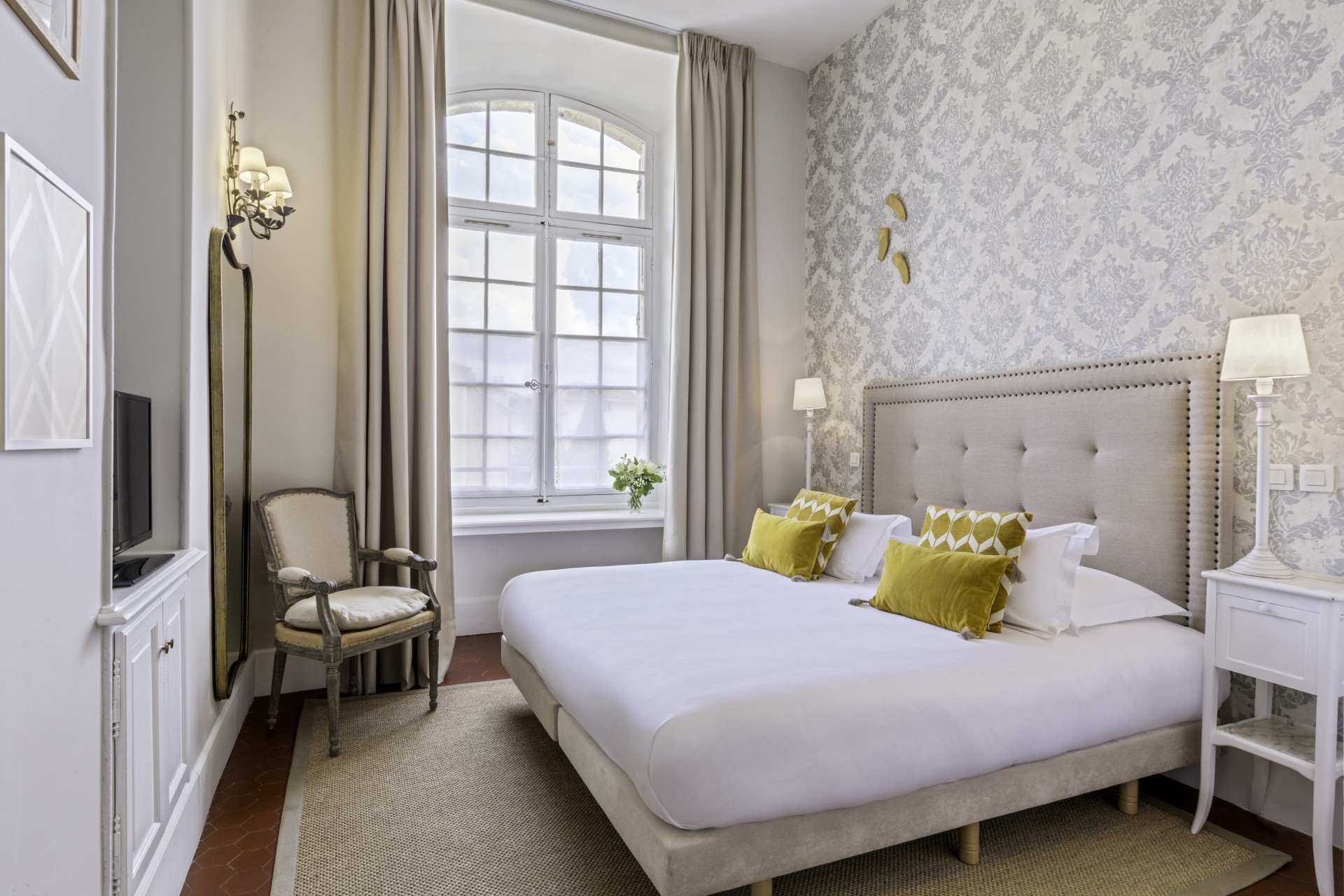 a bed with a lamp and a chair in a room