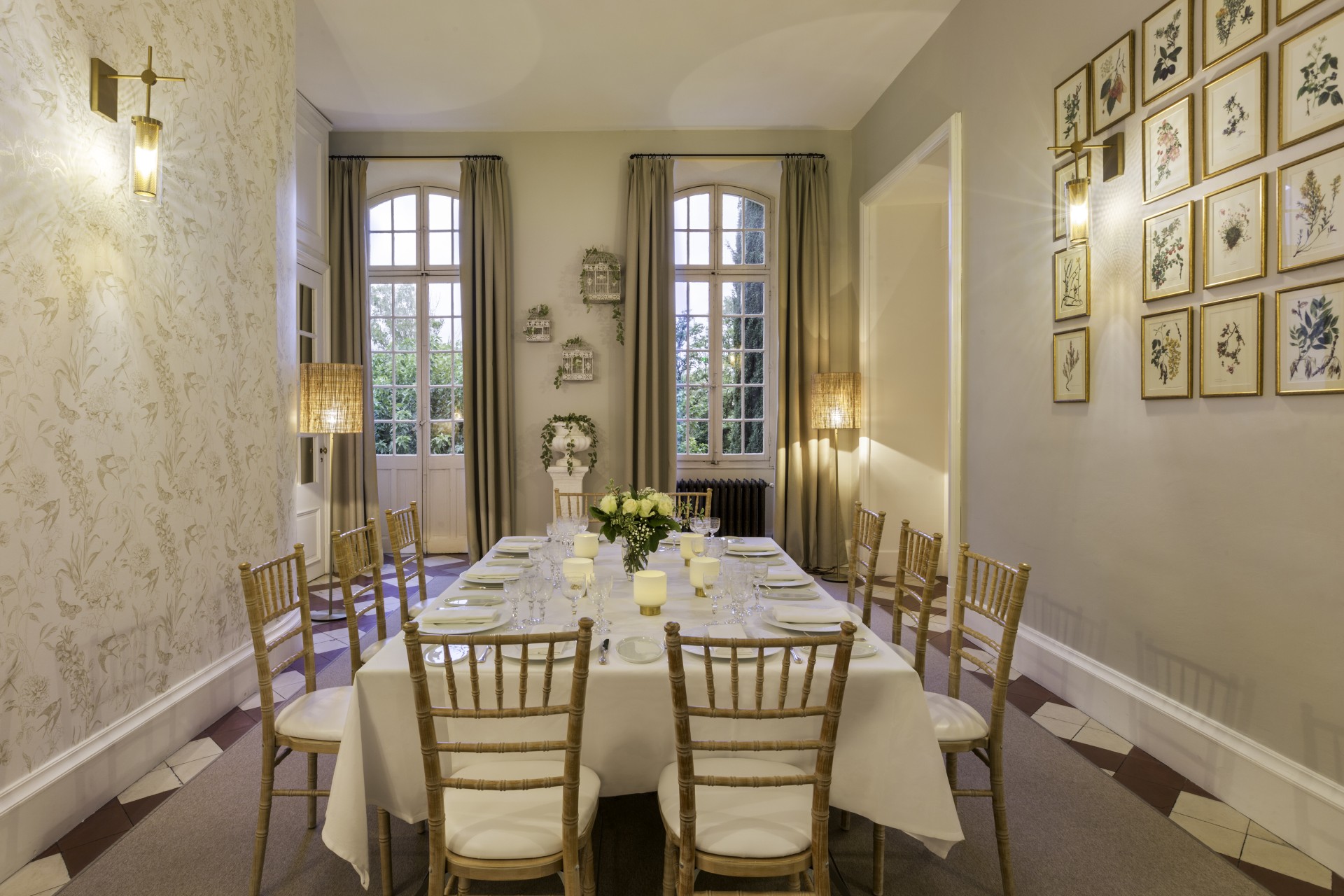 a dining room with a table set with chairs and a flower arrangement