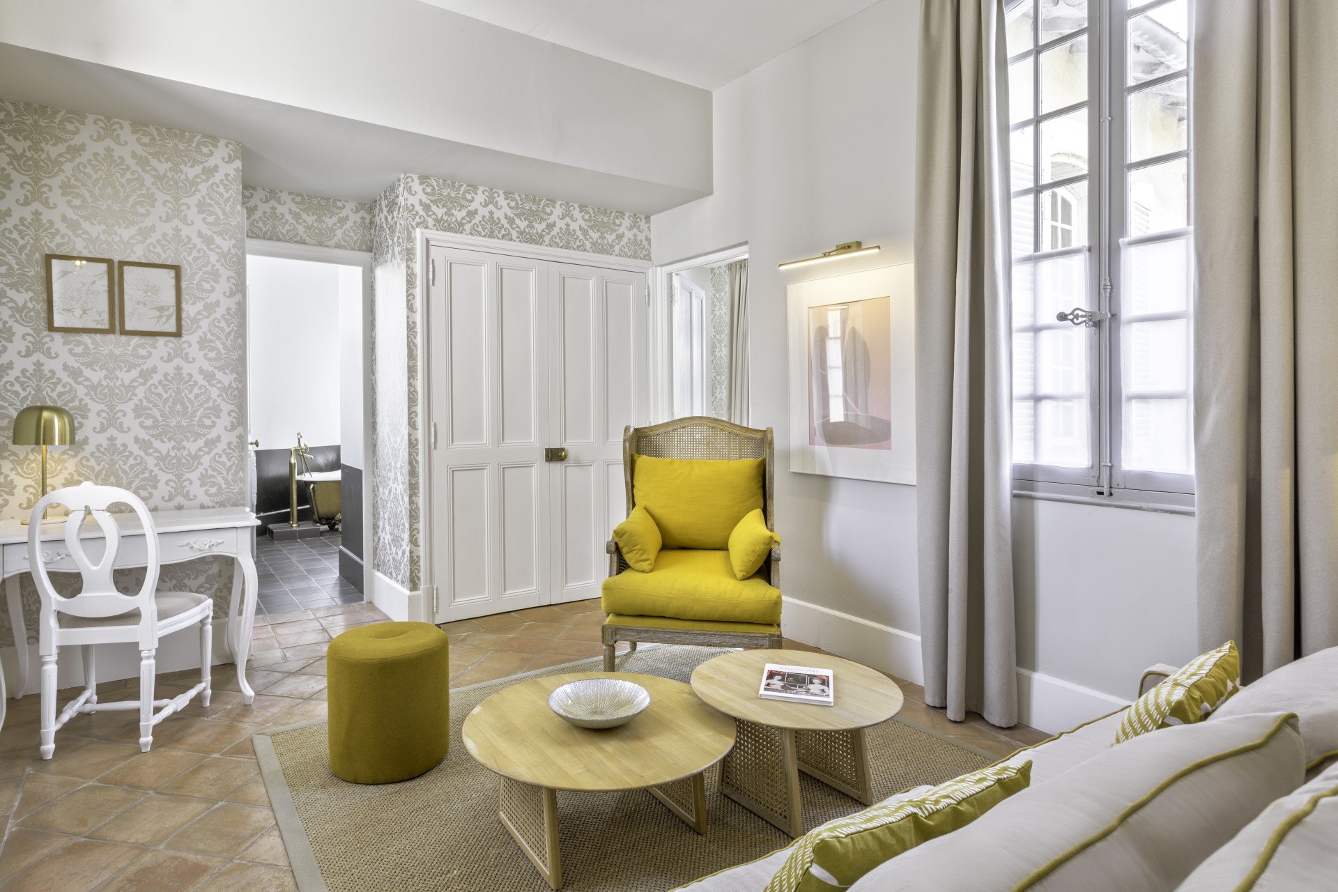 a room with a yellow chair and coffee tables