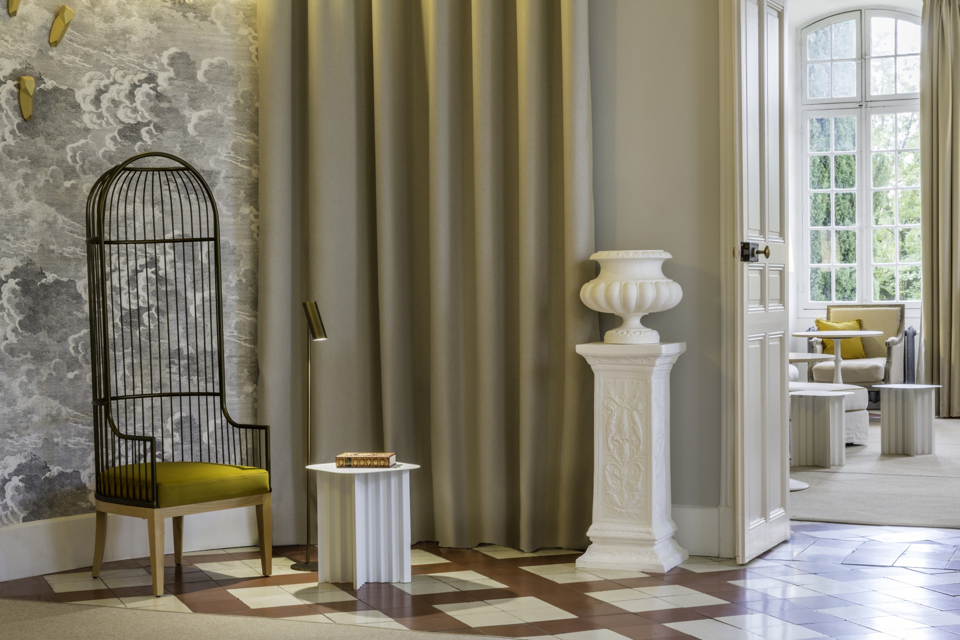 a room with a curtain and a vase on a pedestal